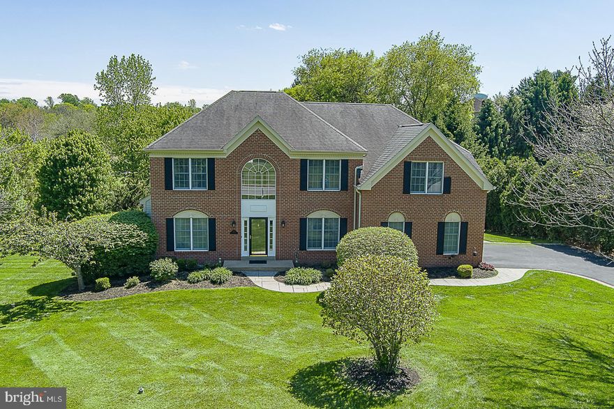 Welcome to this timeless brick-front Federal residence, perfectly positioned on a one-acre-plus lot in the prestigious Cheshire Knoll community. The journey begins in a dramatic two-story foyer, where custom paneling elegantly follows the staircase. The main level is defined by gleaming hardwood floors and classic millwork, featuring a spacious living room with crown molding and a formal dining room designed for hosting. A first floor office with timeless parquet flooring provides views of the mature trees and lovely yard making work from home a pleasure. The heart of the home is the spectacular two-story great room, which is flooded with natural light and anchored by a gorgeous gas fireplace. Adjacent is the gourmet kitchen, a chef's delight boasting granite countertops, island seating for two, and stainless steel appliances including a brand-new refrigerator. The sunny eating area flows seamlessly to the outdoors through sliding doors to the rear deck, which overlooks your massive, ultra-private backyard sanctuary. The second level is equally impressive, accessible by both the main foyer and a convenient back staircase. Retreat to the huge primary suite, a true oasis featuring classic crown molding, three generous closets, and an updated primary bathroom complete with a deep soaking tub, dual sinks and a modern walk-in shower. Three additional spacious bedrooms on this floor share a well-appointed hall bathroom, recently updated with new dual sinks. The full basement offers massive potential, providing abundant storage or the opportunity to easily finish for additional living space (think home theater, gym, or playroom). Completing this exceptional property is a side-entry two-car garage with epoxy flooring and a brick lined driveway. Meticulously maintained and a layout that maximizes both privacy and natural light, enjoy the peace of an acre-plus estate on a cul de sac with the convenience of a West Chester address. This is the one you've been waiting for.