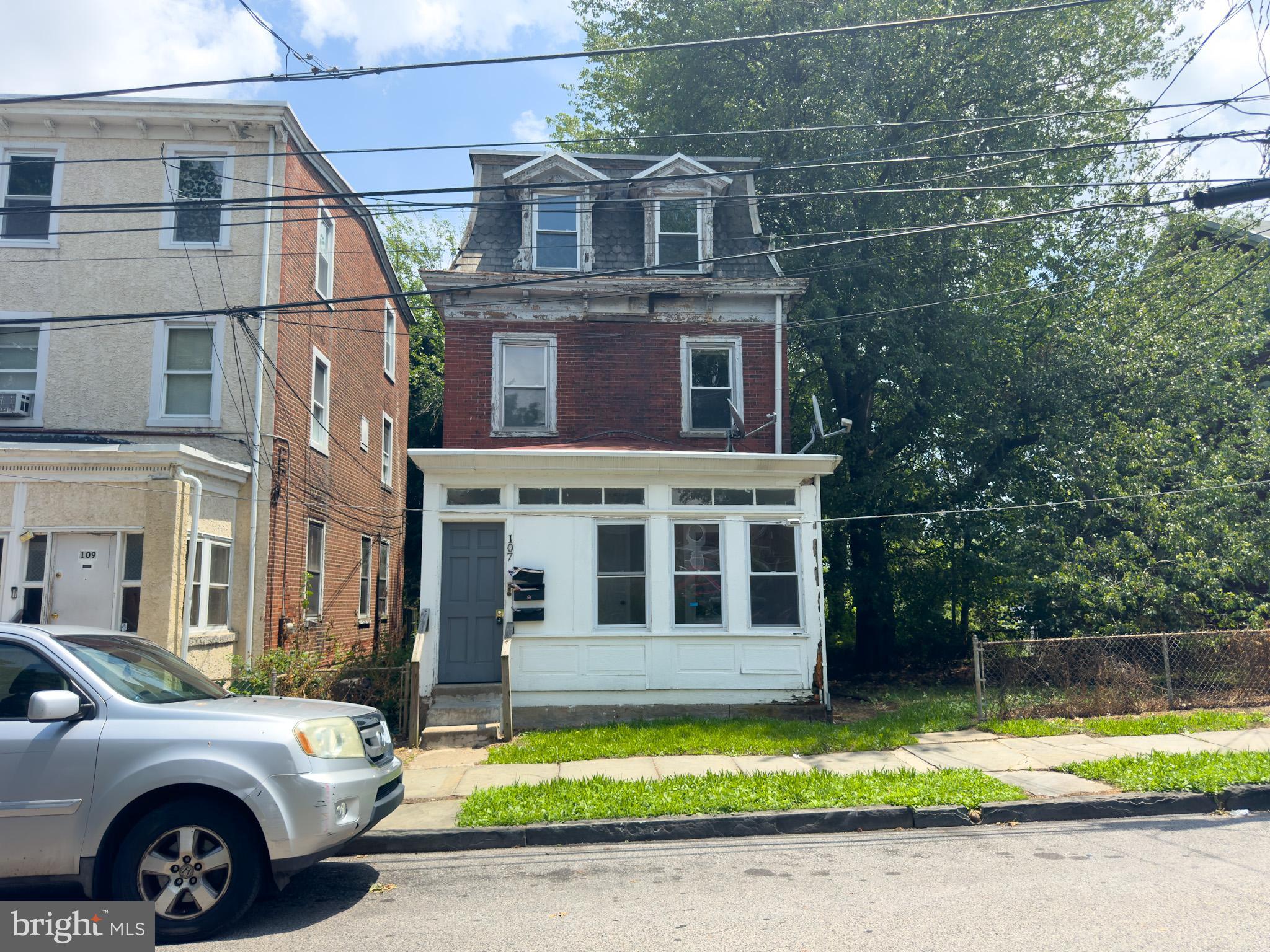 Located in the heart of Darby, PA, 107 N. 6th Street is a fully detached triplex offering over 2,400 square feet of living space across three floors—an ideal opportunity for investors or owner-occupants looking to offset their mortgage with rental income. Each unit features separate utilities and private access via a thoughtfully designed layout. The first-floor unit offers two spacious bedrooms, one full bath, and a generously sized living room. The second and third-floor units each include one bedroom, one bathroom, and a roomy living area, providing comfortable accommodations for tenants. A common enclosed front porch greets you, with two separate entry doors—one leading directly into the first-floor unit and the other providing access to the upper floors via a shared stairwell. Each unit also has access to a rear fire escape for added safety. The property boasts a large rear and side yard, perfect for outdoor enjoyment or future improvements. Conveniently located near the Philadelphia International Airport, public transportation, and local amenities, this versatile property blends space, functionality, and long-term potential.
