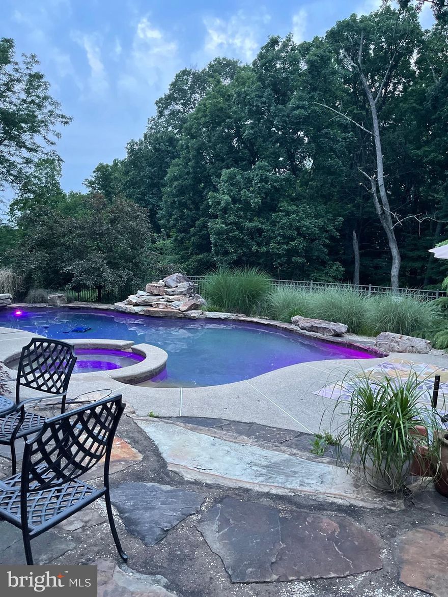 Welcome to a private sanctuary in the sought-after Landis Green neighborhood, served by top-ranked Central Bucks schools. This distinguished 4-bedroom, 2 full and 2 half bath colonial-style home, offered by the original owner, is set on nearly half an acre of beautifully landscaped grounds, offering privacy, elegance, and timeless care. Sunlight fills the home, highlighting rich hardwood floors and an inviting layout ideal for both everyday living and entertaining. The first floor features formal living and dining rooms, a family room with a stone raised-hearth gas fireplace framed by added windows, radiant floors, and a chef’s kitchen with gas range, stainless steel appliances, center island, and breakfast room with access to the porch. A private office with glass French doors, half bath and laundry room completes the main level. Upstairs, the primary suite offers a sitting area, two walk-in California Closets, and a spa-inspired ensuite bath with corner Jacuzzi tub, shower, double vanity, skylights, and additional windows. Three additional spacious bedrooms with closet organizers and a hall bath complete the second floor. The finished walk-out basement is ideal for entertaining, featuring a custom bar, pool table, half bath, and direct access to the backyard. Outside, enjoy a resort-style oasis with a heated saltwater Gunite pool with Pebble Tech finish, heated spa, waterfall, deep-end love seat and step in/out, and LED lighting.Additional highlights include a two-car clear-span garage with attic storage and walking-distance access to Landis Park, offering trails, sports fields, playgrounds, pavilion, and seasonal ice skating. A rare opportunity combining luxury, lifestyle, and location. Schedule your private tour today!