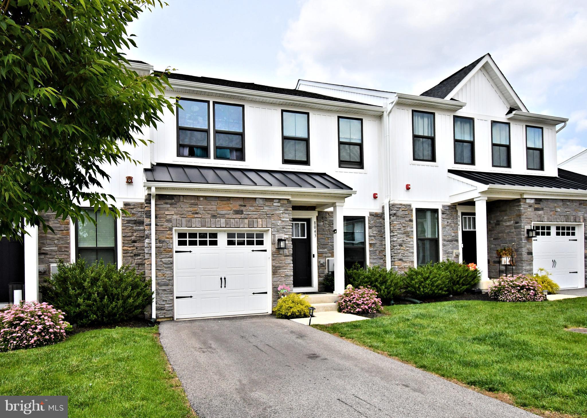 Welcome to 8043 Milltown Circle in Ashbourne Meadows—a stunning, upgraded townhome built in 2022, perfectly situated in one of Cheltenham Township’s most desirable communities. With 2,570 square feet of beautifully finished living space, this 3-bedroom, 3.5-bathroom home blends contemporary style with functional design for today’s modern lifestyle.
Step inside to find a sun-drenched morning room, where oversized windows create a warm and inviting atmosphere—ideal for morning coffee, working from home, or simply unwinding. The open-concept main level seamlessly connects this space to the heart of the home: a chef-inspired kitchen featuring quartz countertops, sleek cabinetry, stainless steel appliances, a gas range, and an oversized island with seating for four. A striking tile backsplash adds a sophisticated touch, while the adjacent dining area and spacious living room make entertaining effortless.
Sliding glass doors lead to a large composite deck overlooking tree-lined views—your own private retreat for dining al fresco or relaxing at sunset.
The fully finished lower level offers exceptional flexibility with an expansive family room, a full bathroom, and a bonus room perfect for an office, gym, or creative space. Thoughtful storage solutions in the mechanical room make seasonal organization simple and efficient.
Upstairs, retreat to a luxurious primary suite with vaulted ceilings, a generous walk-in closet, and a spa-like en suite bathroom complete with a walk-in shower and private water closet. Two additional bedrooms are located down the hall, along with a stylish full bathroom and a convenient upstairs laundry room.
Located in the sought-after Cheltenham School District, Ashbourne Meadows offers the best of suburban living with easy access to city amenities. Enjoy nearby shopping and dining at Greenleaf at Cheltenham and Willow Grove Park Mall, outdoor adventures at Tookany Creek Park and Curtis Arboretum, and leisure at Melrose Country Club. Commuters will love the quick access to Route 611, the PA Turnpike, and multiple regional rail lines—making travel to Center City and Northeast Philadelphia a breeze.
Stylish, spacious, and thoughtfully designed, this Ashbourne Meadows gem isn’t just a home—it’s a lifestyle. Come experience the perfect balance of luxury and livability.