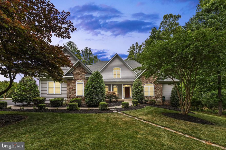 Come enjoy unforgettable sunset views over Lake Anna from this impressive luxury waterfront home, offering 6,400 square feet of beautifully designed living space on a 1.9-acre lot with 125 feet of shoreline on the private side of the lake. Located in The Village at Lake Anna, this exceptional property offers a prime setting with gorgeous lake views, deep water, peaceful waterfront living, and even great views of the annual Fourth of July fireworks show by water near Dike 2. Even better, most furniture and furnishings convey, making it easier to start enjoying lake life right away. Recently appraised for $2,700,000, this property presents an incredible value and a sweet opportunity for immediate equity. Appraisal is available in the MLS documents section. Designed with space, comfort, and elevated lake life in mind, this expansive home features 6 bedrooms plus an office and 4 full baths. The main level showcases hardwood flooring throughout and a thoughtful layout made for both everyday living and entertaining. The spacious living room offers soaring 12-foot ceilings and 10-foot lakeside windows that fill the home with natural light and frame beautiful water views. The great room is warm and inviting with a stone gas fireplace, built-in shelving and cabinetry, and an easy flow into the gourmet kitchen. The kitchen is well-appointed with granite countertops, a 5-burner gas cooktop, double wall ovens, stainless steel appliances, tile backsplash, center island, walk-in pantry, and plenty of space for gathering. Enjoy casual meals in the breakfast room with a charming bay window, or host family and friends in the separate dining room. The main-level primary suite with lake views has its own sitting area, a walk-in closet, and a spacious bath featuring a walk-in tile shower, heated floors, and instant hot water in the shower. The main level also includes a home office or additional bedroom with an adjacent full bath, plus a mudroom with laundry for added convenience. Upstairs, guests will appreciate three spacious bedrooms and a full bath, offering plenty of room for family and friends. The walkout lower level adds even more living and entertaining space with a large lakeside family room, wet bar closet, game room, two additional bedrooms, and a full bath. Just outside, a welcoming screened porch and adjoining stone and brick patio create the perfect place to relax after a day on the water. Enjoy the lakeside back deck with a gas line for the grill, perfect for cookouts, entertaining, and taking in the water views. A golf cart path leads to the water’s edge, making trips to the shoreline and boathouse easy and convenient. Gather around the stone fire pit patio by the water and take in stunning Lake Anna sunsets, rinse off in the outdoor shower, or enjoy the naturally sandy shoreline protected by riprap. The area between the shoreline and boathouse creates a wonderful protected swimming area, ideal for enjoying lake days with family and friends. The property also includes an invisible dog fence, adding extra peace of mind for pet owners. The boathouse is ready for all your waterfront fun with deep water, two slips, electric lifts, a screened porch, large sun deck, and a spacious enclosed storage room for lake toys and gear. Additional features include instant hot water in the kitchen, heated primary bath floors, security system, water treatment system, 3-zone HVAC replaced in 2020, tankless gas hot water, paved driveway, 3 car attached garage, storage shed, invisible dog fence, and most furniture and furnishings conveying. This is the kind of Lake Anna home where everyone has room to spread out, gather together, and make the most of every sunset, swim, boat ride, and summer celebration.