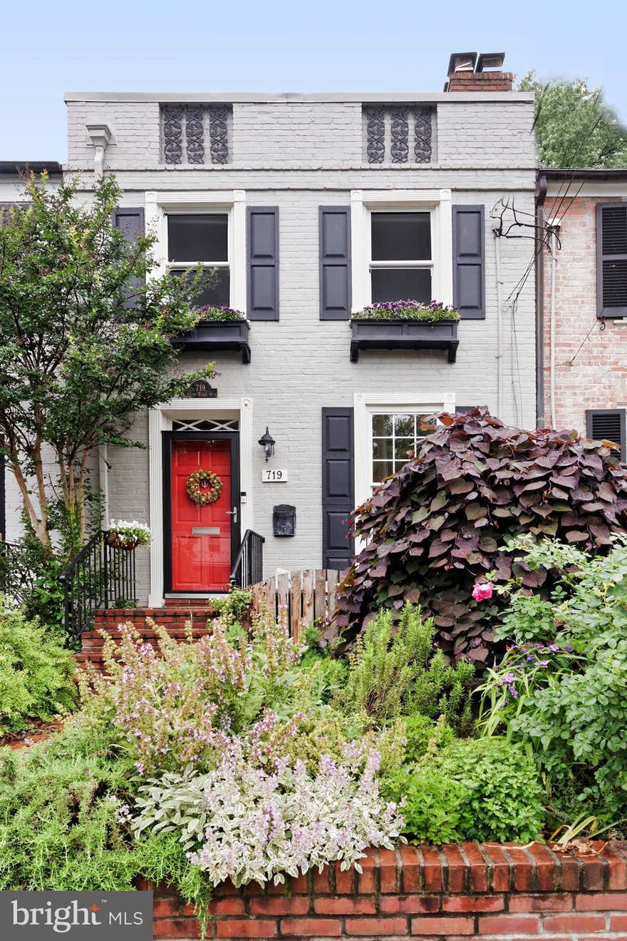 A gardener's paradise in sought-after Yates Gardens, this 2-bedroom, 2.5-bath brick townhome blends historic charm with modern updates.   Hardwood floors, two fireplaces, and two skylights create a warm, light-filled interior. The inviting living room offers a wood-burning fireplace, detailed molding, and built-in bookshelves.   Perfect for entertaining, the open kitchen features stainless steel appliances, granite countertops, sleek vent hood, and a breakfast bar.  It flows seamlessly into a bright family room where a wall of glass doors open to the deep patio.  A main-level powder room adds convenience.  The lower-level recreation room with a gas fireplace, full bath, and laundry/storage room is perfect for flexible living. Outside, a brick-fenced, two-tier patio and garden, featuring mature trees and lush plantings including hostas, wild geraniums, hydrangeas, and azaleas, creates a private outdoor retreat with a large shed and new power outlets on the upper patio.  Conveniently located near the Old Town waterfront, King Street shops, restaurants, and metro, this home offers Old Town living at its finest. The fireplaces convey as-is, as the owners have never used them. The total finished square footage is 1,384, including the lower-level rec room and full bath.