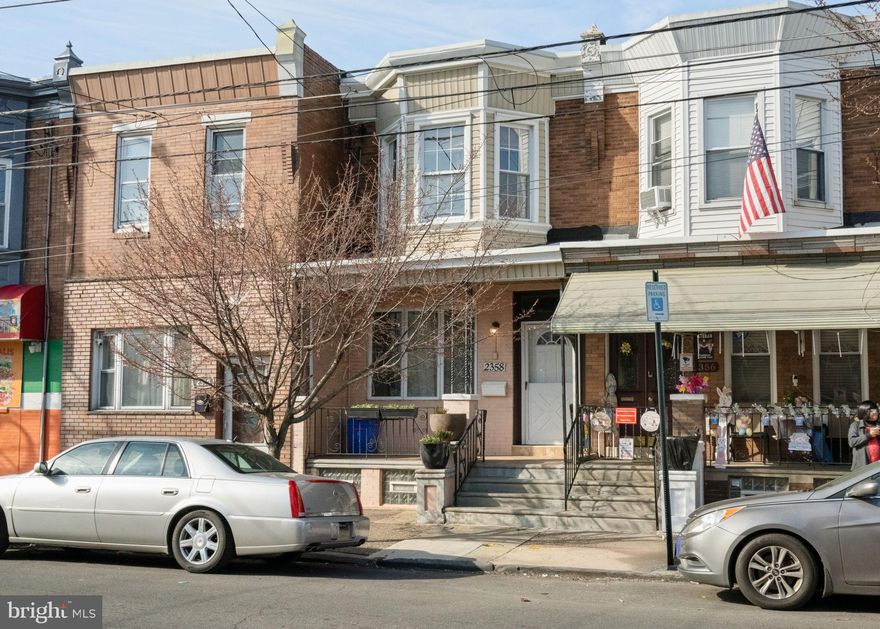 Step onto the sweetest covered front porch on the block accented with planters for that unmistakable Port Richmond charm. Inside, a beautifully preserved vestibule sets the tone with original woodwork, inlaid tile flooring, and stunning double doors adorned with dentil molding. Above, a leaded glass transom filters in soft light, giving this entry a level of character you simply can’t recreate. The home opens into a bright, airy living and dining space where classic details meet everyday comfort. Light parquet flooring flows throughout, while the original fireplace mantel, now a decorative focal point anchors the living room with warmth and history. Thoughtfully placed closets in both the living and dining areas add the kind of storage you didn’t know you needed but won’t want to live without. The kitchen is generously sized and truly functional. Just beyond, a dedicated laundry room with additional storage and a first-floor powder room adds a level of convenience. Upstairs, three bedrooms continue the light parquet flooring and feature updated lighting throughout. The full bathroom has been completely reimagined into a spa-like retreat, featuring a large walk-in shower with a rainfall showerhead, crisp white subway tile, hexagon tile flooring, and a custom vanity crafted from reclaimed beams. Finished with black fixtures and lighting, it’s a perfect blend of modern edge and timeless design. The primary bedroom is spacious and filled with natural light, complete with double closets for easy living. Out back, enjoy a private patio with a recently installed wooden fence ideal for morning coffee, summer nights, or creating your own outdoor escape. The Sellers have made some major updates including  new central air (installed 2022), a new roof (2024), and a new curb trap & rear water leder and drain (2025) giving you peace of mind for years to come. Located in the heart of Port Richmond, this home delivers that true neighborhood feel, just one block from the local rec center, a short stroll to Her Daughters Café, and convenient access to shopping, public transportation, and everything the surrounding Riverwards have to offer.