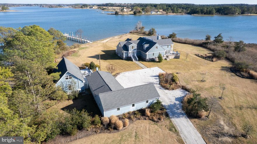 Nestled on the private four-acre waterfront enclave of Three Creeks Point, this extraordinary estate offers breathtaking sunrises and sunsets over Fishing Creek with sweeping southerly views of Church Creek spanning more than 180 degrees. The primary residence features 5 bedrooms, 4.5 baths, and over 5,400 square feet of thoughtfully designed living space, complemented by an expansive maintenance-free wraparound deck providing panoramic water views from nearly every angle.
Enhancing the main residence is a separate 2-bedroom, 1.5-bath guest home featuring a Primary Bedroom on the 1st floor with full bath and additional bedroom in the loft with adjoining half bath. The guest home is complete with a full kitchen, laundry, private deck, and tranquil water vistas — ideal for hosting guests or multi-generational living. Just minutes from the open Chesapeake Bay, this property boasts approximately 6 feet mean low water (MLW) along the protected waters of Fishing Creek, creating exceptional opportunities for boating, fishing, crabbing, paddleboarding, and kayaking along the quiet creeks of the Little Choptank River.
The L-shaped pier is fully equipped with an electric boat lift, jet ski lift, and multiple slips, offering ease of waterfront access. Recent extensive exterior improvements and renovations have enhanced both the low-maintenance appeal of the property and maximized the stunning waterfront views.
Inside, the home showcases a spacious open layout perfect for everyday living and entertaining. The Great Room is filled with natural light and opens seamlessly to the wraparound deck, creating a remarkable indoor-outdoor flow. The Brand-New 2025 Kitchen is the heart of the home, completely remodeled with high-end finishes and designed to serve both the casual homeowner and the enthusiastic entertainer alike. New hardwood flooring throughout the first floor elevates the living spaces while maintaining warmth and coastal elegance.
Formal living and dining areas provide refined entertaining space anchored by a stunning stone fireplace, while the sunroom, spanning the width of the home, delivers captivating eastern, western, and southern water views that shift beautifully throughout the day.
The main level includes two bedrooms and a full bath tucked into a private alcove, offering comfortable guest accommodations or flexible living options. The upper level hosts the impressive primary suite, complete with vaulted ceiling, fireplace, private waterside balcony, spa-inspired ceramic tile bath with walk-in shower, and spacious walk-in closet. Two additional bedrooms and a full bath are also located on the second floor. An oversized office with vaulted ceiling and its own balcony provides an inspiring remote workspace overlooking the water.
The guest house is equally inviting, featuring a first-floor bedroom and bath, full kitchen, stacked washer and dryer, and a second-floor bedroom with loft area — perfect for extended stays.
A detached four-car garage offers ample storage for vehicles, water toys, and workshop needs.
With its unrivaled waterfront views, deep water access, private setting, generous living spaces, updated interior features, guest accommodations, and extensive dock amenities, this exceptional property represents the pinnacle of luxury Eastern Shore living.