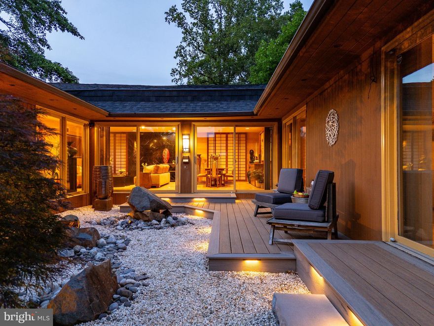 OFFER DEADLINE IS SUNDAY 6/29 by 5PM.  Discover a rare fusion of architecture, nature, and serenity at 411 Clairemont Road—a one‑of‑a‑kind mid‑century modern home infused with Japanese Zen influences, tucked away on a serene, tree‑lined street in the heart of Villanova, Lower Merion Township. Offering 3 bedrooms, 3.5 bathrooms, and the flexibility for a fourth bedroom, this expansive 3,442‑square‑foot residence delivers the convenience of one‑floor living on a beautifully flat and private ¾ acre lot that feels surprisingly expansive and hidden from view.

From the street, the home appears understated and modest—but step inside and the experience shifts dramatically. Vertically aligned cedar siding and natural stone accents give way to walls of glass, minimalist architectural lines, and curated materials, all centered around a breathtaking Zen courtyard. Professionally designed, it features sculptural illuminated boulders, raked gravel, and a tiered composite deck that’s visible from nearly every room—an ever-present invitation to pause, reflect, and breathe.

Step through the double front doors to a view of the Zen courtyard bathed in natural light. To the right lies the bright, airy living and dining area, framed by shoji-style panels and expansive glass—ideal for intimate gatherings or quiet mornings.

Just beyond the living area, the kitchen is as stunning as it is functional, with granite countertops, custom cabinetry, a central island with a glass breakfast table, built-in desk, built-in pantry, and premium appliances including a GE Monogram refrigerator, Thermador hood, Dacor cooktop and ovens, and Sharp microwave.

Across from the courtyard, a quiet den awaits—perfect for a home office, media room, or potential fourth bedroom—with sliding glass doors overlooking the garden.

The heart of the home is the stunning family room, showcasing stepped ceilings, recessed lighting, polished marble floors, and a central skylight. Wall-to-wall glass and French doors reveal an expansive composite deck and a flat, private backyard—featuring lush lawn, mature trees, and a convenient half basketball court.

The primary suite is its own sanctuary, with direct courtyard access, a generous walk-in closet, and a spa-like marble bath with dual vanities, sculptural soaking tub beneath a circular skylight, and elegant gold fixtures. Two additional large, light-filled bedrooms offer generous proportions, recessed lighting, garden views, and ample closet space—served by an updated shared hall bath.

Directly off the kitchen, the finished lower level includes a full bathroom, laundry room, storage, and flexible space for a gym, playroom, or guest suite.

Completing the experience is a two-car attached garage, roof and gutters (2021), hot-water heater (2021), two-zone HVAC, courtyard deck and zen garden (2020), full basement waterproofing (2016), and a reliable backup generator.

Surrounded by mature Japanese maples and lush landscaping, and ideally located just minutes from Black Rock Middle School, the Villanova train station, King of Prussia, and with direct access to Center City Philadelphia in under 25 minutes, 411 Clairemont Road is more than a home. It’s a private, spacious sanctuary that surprises, delights, and offers modern elegance—all on one remarkable floor.