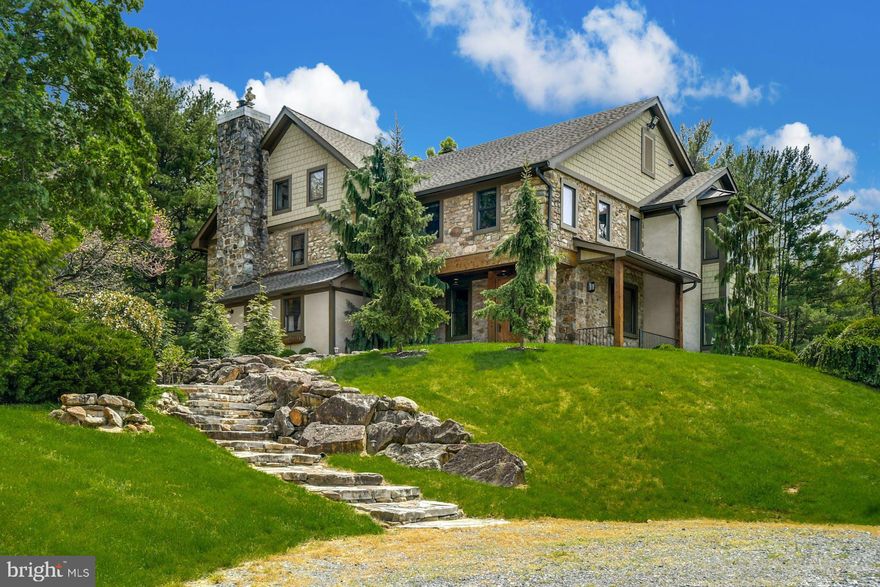 Approach over your own COVERED BRIDGE, across the meandering STOCKED TROUT STREAM of LAUREL RUN, to your home’s vantage point, overlooking a Currier and Ives setting. This 1800’s STONE HOME was completely reimagined in 2013/2014 to create a unique residence that combines space, light and imagination. Steeped in history, there are marvelous architectural features at every turn.  
Inside, warm wood flooring, custom cabinetry, EXPOSED STONE WALLS, antique POST AND BEAMS, CATHEDRAL CEILINGS and stunning window placement set the mood for a PERFECT RETREAT . The interior was completely reimagined, enhanced by WALLS OF GLASS, and boasting a FOLDING GLASS DOOR  from the great room to the terraces. The resulting achievement is a spacious, airy, light-filled home.  The beautifully equipped cook’s kitchen features the FINEST APPLIANCES. Just outside, a covered loggia with STONE FIREPLACE is ideal for seasonal dining.  
Upstairs, a PRIMARY BEDROOM SUITE, with stunning bath, is a romantic oasis overlooking enchanting views. Three additional bedrooms on the second and third floors are distinctive, with VAULTED AND BEAMED CEILINGS and voluminous windows.  
Apart from its many masterful design elements, the home is equipped with the finest mechanicals, including RADIANT FLOOR HEAT AND A GENERATOR.  A BANK BARN/garage, with a lower-level workshop, is a charming addition that is both functional as well as beautiful. Whether fishing in your own corner of paradise or walking the adjacent rails-to-trails, Laurel Run answers one’s wish to have it all.