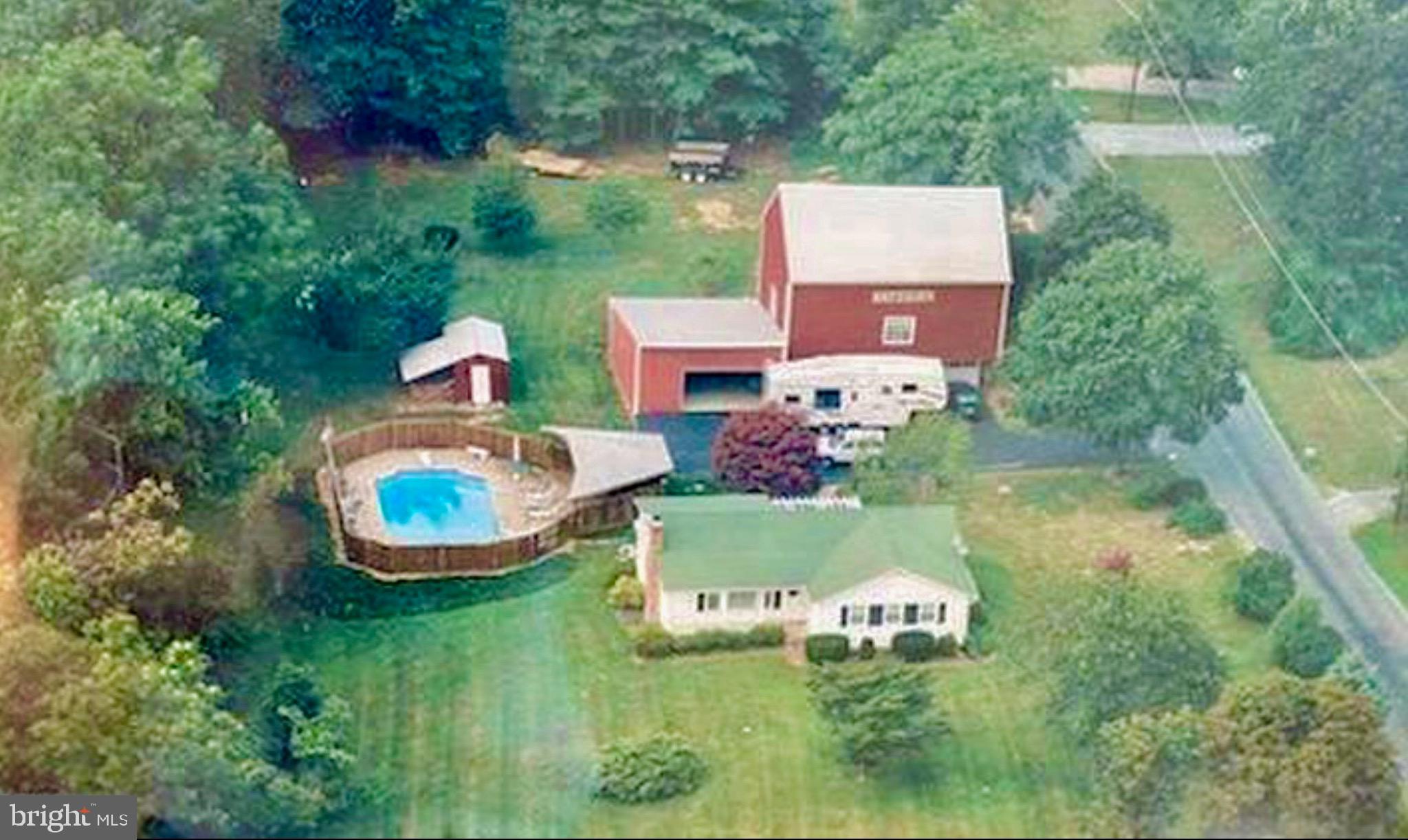 Rancher on 1.33 acres with a barn, huge outbuilding & a fenced in pool. Walk into your spacious living room with natural oak hardwood flooring & a wood burning fireplace. Kitchen with custom cabinets, lots of counter space and new stainless steel appliances. Dining room off kitchen with chair rail molding and bay window. Sunroom with views of the backyard and pool. Owners bedroom with private bathroom with an updated shower with ceramic tile and a glass door. Bedrooms 2 & 3 are a great size and share a 2nd full bathroom. Huge unfinished basement with room for the next owner to add finished sq feet to the home. Nice back patio great for grilling on summer days. Pool area is fenced and has a covered area to keep in the shade while entertaining guests in the pool. Massive garage that could be a repair shop for a mechanic or you can store your boat and sports car. Two level outbuildings that could be converted into an amazing man cave of she shed. This can be a perfect game room oasis. Great location in the country but close to shopping, restaurants and major highways.