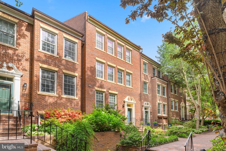 Nestled within the Cloisters Community in Georgetown's West Village, this elegant brick townhome offers generously sized rooms spanning approximately 3,500 square feet over four levels with elevator.  This turn-key home showcases a recently renovated stylish kitchen AND beautifully updated bathrooms.  The floor plan includes 4 total bedrooms all with ensuite bathrooms - 2 bedrooms are large primary suites!  There is also a dedicated office that could easily be converted to a 5th bedroom.  The home's interior boasts gleaming hardwood floors, high ceilings and a well-appointed kitchen equipped with top of the line appliances, catering to both everyday living and large scale entertaining. The formal dining area opens to the light filled formal living area with wood burning fireplace and ample space for two sitting areas.  The lower level offers the fourth bedroom with ensuite full bathroom plus separate family room with the second wood-burning fireplace, wet bar and access to outdoor patio.  An in-home ELEVATOR enhances accessibility across all levels, while large custom closets offer abundant storage solutions.​  Separate one car garage + adjacent second car parking pad lead to the private brick garden patio - perfect for relaxing, dining outdoors and growing a small herb garden. 
Excellent location in quiet enclave of Georgetown.  Close proximity to shopping and dining- enjoy a 5 minute walk to the shops and restaurants on Wisconsin Ave & M Street plus an easy walk to grocery stores: Safeway, Trader Joes & Whole Foods!