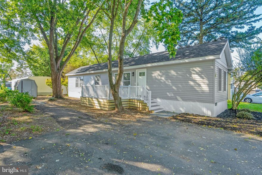 Welcome to this beautifully remodeled in 2025 manufactured home in the sought-after Whispering Pines community—redone down to the sheetrock and subflooring! With upgrades including a new roof, windows, deck & railings, HVAC, electrical, plumbing, appliances, and more, this 2-bedroom, 2-bath home offers the comfort and feel of a brand-new build.
Step onto the brand-new front deck, surrounded by mature trees, and enter an open-concept living space featuring luxury vinyl plank flooring throughout. The light-filled living room flows into a spacious dining area and a modern kitchen, complete with all new white cabinetry, tile-accented walls, recessed lighting, stainless steel appliances, and a window above the double sink that looks out onto the peaceful yard.
The primary bedroom includes a generous walk-in closet and a private ensuite bathroom with a step-in shower, new vanity, and all new fixtures. A second bedroom and fully remodeled bath offer comfort and flexibility for guests or home office use.
Outside, enjoy the privacy and shade of mature trees, plus a storage shed for your beach gear and bikes. Whispering Pines offers a community pool, playground, basketball court, and covered picnic area—everything you need for an active lifestyle.
Located just 10 minutes from downtown Lewes and its beaches, boating, and outdoor recreation, with easy access to Route 1, shopping outlets, dining, and Rehoboth Beach just minutes away. Conveniently located near schools, grocery, pharmacy, and hospital/medical care, this is your move-in ready coastal retreat!