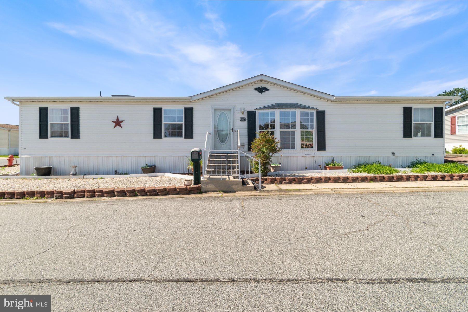 Buyers need to be pre-approved by the park prior to sale.
Move-in ready 3BR/2BA double wide Mobile Home on a corner lot located in the quiet community of Peppermint Woods. Step inside to a home filled with natural light, hardwood floors, vaulted ceilings, sky lights, a large sunroom, and an open floor plan. The main living area offers a large living room featuring a wood burning fireplace with a solid wood mantel, a large dining room, and an open kitchen. The kitchen features plenty of cabinets finished with crown moldings including a pantry, an abundance of counter space, a double stainless sink under a window, and an island with seating for four. Just beyond the kitchen is laundry, and down the hall are two sizable secondary bedrooms, and a full bath. Off the living room is the primary suite boasting a large bedroom with a vaulted ceiling, a private en suite featuring a deep jetted soaking tub, a double sink vanity, a walk-in shower, and a walk-in closet. From the kitchen step into a wrap around screened-in sunroom with plenty of space for hosting family and friends. This home is move-in ready, offers so much to new homeowners, and is located in close proximity to shopping, restaurants, and commuter routes.