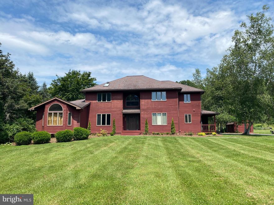 Embrace the picturesque and private setting, yet live close to town and campus. Looking for elbow room, this is it! Enjoy this convenient location with Wegmans just minutes away and vast open space both inside the home and out! The home layout offers flexibility with multiple bedroom arrangements. The home boasts three huge bedrooms/baths on the second floor. The owners' ensuite is massive with more high ceilings and even a private balcony.  The main floor office can easily be used as the fourth bedroom. The lower-level walkout basement contains another bedroom, number four or five. This home has an understated grandness. The sixteen-foot beamed ceilings in the kitchen and family room, combined with extraordinary windows/views, embody a sense of tranquility, a calming factor, as nature is brought inside. Daylight splashes all around and above, creating a sense of awe! The spacious kitchen has enough counter space and cabinets to accommodate any gathering while not compromising the cozy feel we all need.  Bring on your green thumb, and plants will flourish in the bumpout atrium across from the kitchen sink. Doing dishes just got a lot easier!  Dining at the kitchen table, below the massive arched window overlooking a park-like setting, never grows old! The kitchen/living room combination is perfect on all fronts. The family room height is accentuated with the floor-to-ceiling brick hearth, and the new wood pellet stove adds enjoyment to the winter months.   The two-story light-filled foyer has perfect symmetry with double French doors at the opposite side of the house.  The dining room boasts a wood ceiling, wood floors, and a wet bar, communicating ideally with the surrounding rooms. The living room has a beautiful brick arched wood fireplace, creating a timeless style.  Private outdoor enjoyment on the massive wrap-around deck is perfect for any large or small occasion or simply relaxing without neighbors.  The walkout basement has many opportunities with natural light, French doors, and defines flexspace for your individual needs. A side-covered service entrance with a porch is handy for Amazon packages or drinking coffee while watching the sunrise to the east.  Enjoy the extra storage with the huge shed near the garage.  Enjoy low heating/cooling costs with the brand new HVAC system!