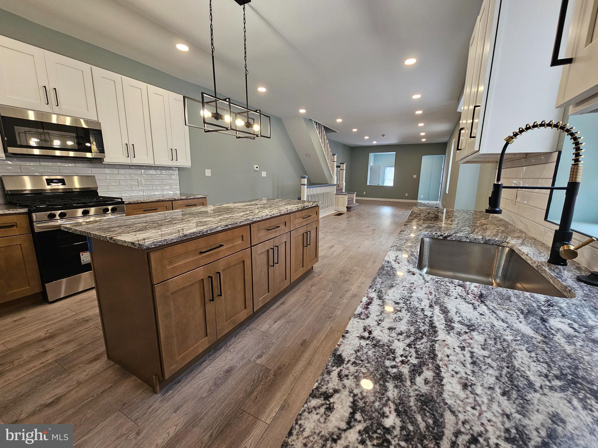 This completely renovated, spacious twin house is located in the desirable Logan neighborhood. The convenient location offers close access to public transportation, shops, and restaurants. Enter through the mudroom with closet storage into an open floor plan that seamlessly connects the living room and dining room to the brand-new kitchen featuring an island. The gorgeous kitchen boasts granite countertops, modern cabinetry, and brand-new stainless-steel appliances including a stove, microwave, and dishwasher. Adjacent to the kitchen, you'll find a spacious powder room and laundry area. The back door opens to a nice-sized yard. Upstairs, the master bedroom features a beautiful brand-new bathroom with double vanity. Three additional bedrooms and a stunning new hall bath complete the second floor. The full basement has been completely finished, creating perfect space for additional living areas or a family room. Recent updates include new HVAC, water heater, electrical, plumbing, doors, and windows throughout the home. Don't miss the opportunity to own this gorgeous home! Schedule a showing today!