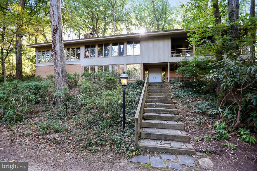 Secluded mid-century modern on two acres is ready to be brought up to date by new owners.  Over 4000 square feet of finished area with expansive open areas on two levels; including two fireplaces, living and dining areas, a superb sunroom, and lower-level family room and den areas. The two-car garage has been used as an art studio and can be converted back.