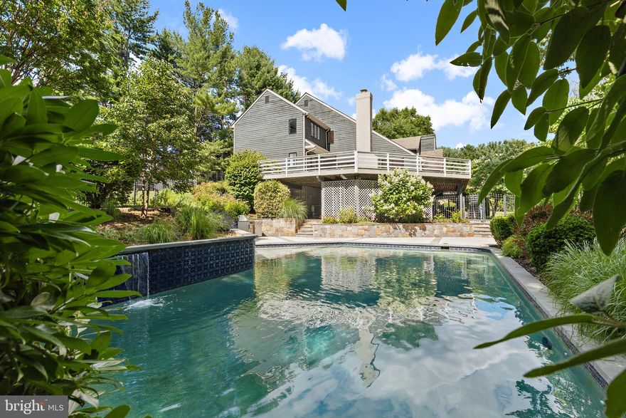 Contemporary Home in Greenspring Valley w/ Lagoon Style Saltwater Pool next to Castanea Estates. This 6 Bedroom 4.5 Bathroom home has been given a fresh modern update throughout its 5,200 square feet of living space, to include a redefined kitchen, all new bathrooms, new HVAC equipment, and more. The main living level is airy and bright with vaulted ceilings, multiple skylights, and various access points to the outdoors. The new Chef’s grade kitchen features Stainless Steel Viking Appliances, Calcutta Quartz countertops & backsplash paired alongside custom cabinetry and custom lighting. The dining room and living room seamlessly flow together and out onto the expansive wrap around deck, which overlooks the sparkling inground pool and lush backyard, and makes for the perfect setting for spring al fresco dining. 2 Gorgeous Fireplaces can also be found at separate ends on the main living level creating a cozy atmosphere anytime of the year. The main primary suite is an oasis of its own with the completely reimagined en-suite bath featuring a rejuvenating soaking tub, double vanity, and invigorating walk-in shower with a rain shower head, multiple body jets, and body wand. 4 more Bedrooms and 2 full bathrooms can be found on the second level, and on the lower level, the fully finished basement offers an additional bedroom and full bathroom, along with additional entertaining space. A custom bluestone ledge accents the outdoor pool area and custom pool deck in the park like setting of the expansive back yard, which comes complete with a stainless-steel outdoor cooking station, perfect for those steamy summer nights.