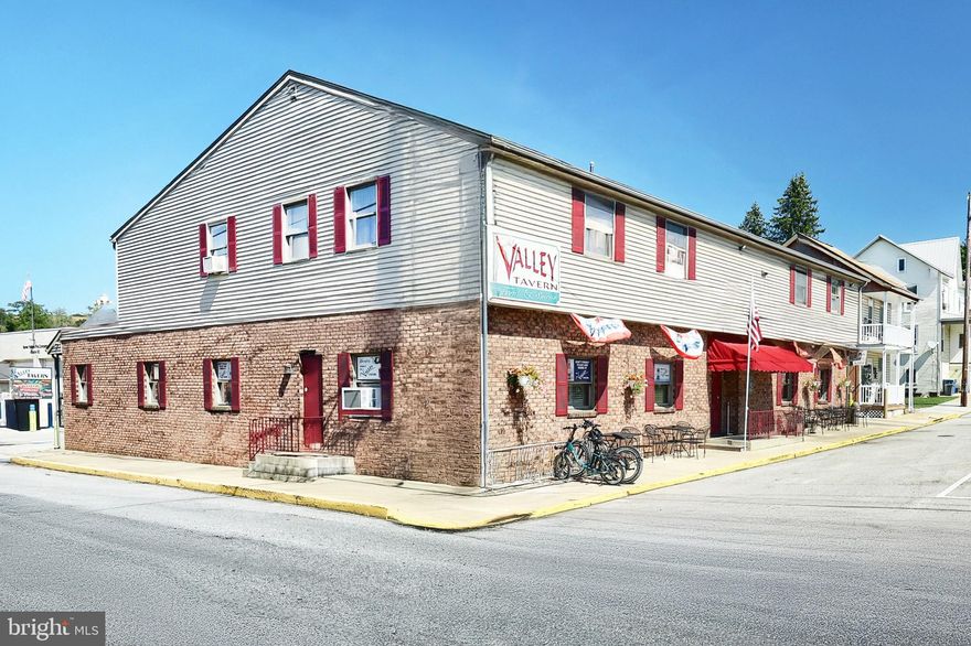 Step into a piece of York County history with The Valley Tavern. This iconic bar & restaurant has been a community cornerstone since 1875, originally opened by Daniel Henry as The National Hotel. 
After a devastating fire in 1985, the building was reborn, yet continues to preserve its storied legacy. 

What Makes It Special

Dual Atmosphere: One side serves as a lively bar, the other as a full-restaurant known particularly for its crab legs, broiled crab cakes, and legendary broasted chicken. Perfect whether guests want a casual drink, dinner, or both. 

Carry-Out & Convenience Features:
• A six-pack walk-out service for those wanting beer to go. 
• A drive-up window so customers can pick up food or drinks without leaving their vehicles. 

Trailside Destination: Situated directly on the York County Heritage Rail Trail, The Valley Tavern is a natural stop for walkers, hikers, and bikers. It benefits from consistent foot- and trail-traffic. 

Mixed-Use Potential: Two long-term apartments upstairs plus a large office space.  The office could be converted into an additional residential unit for extra income. 

Outbuilding & Storage: There is a large detached garage offering significant additional storage capacity especially valuable for a business with food/beverage inventory and seasonal equipment.

Historical & Local Significance

Originated in 1875 as The National Hotel. Tavern licenses dating back to the early 1900s are still proudly displayed. 

The building has survived storm damage (including from Hurricane Agnes in 1972) and was destroyed by fire under the Lippy family’s ownership in 1985; fully rebuilt since that event. 

While the exact date the name “The Valley Tavern” replaced “The National Hotel” isn’t clearly documented on the sources we reviewed, it likely transformed sometime in the mid-20th century under different ownership.

Financial & Business Strengths

The business has strong, growing revenues and profitability for the region. Year after year, sales have increased, driven in part by its location and loyal customer base. It draws traffic not just from locals but from trail-goers and visitors, giving it both consistent and seasonal demand.

Key Assets & Opportunity

Location & Visibility: Trail-side and on a main street of Seven Valleys, high visibility, easy access.

Dual income streams: Restaurant/bar income + rental income from upstairs residences/offices.

Room for growth: The upstairs office could expand income by being converted into housing; enhancing marketing (especially trail & outdoor community) could increase off-peak traffic.

Amenities: Detached garage/storage, carry-out window, six-pack walk-out, separate bar & restaurant areas.

In Summary

The Valley Tavern is more than just a bar & restaurant. It’s a landmark, a business with deep roots in York County history, a prime location serving both locals & trail traffic, multiple income sources, and strong sales performance. For someone seeking a turn-key hospitality business with charm, history, and upside, this is a rare find. Sale includes property, business, liquor license and all equipment and inventory.