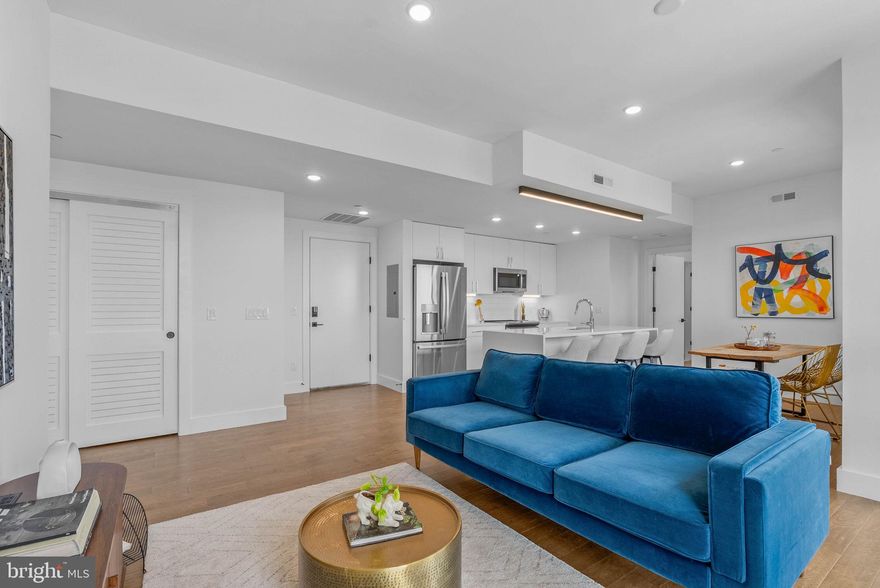 Welcome to Otto on the Park, a sophisticated collection of contemporary condos offering the convenience of parking and more. Enjoy a tax abatement through 2032! Amidst a burgeoning neighborhood, this unit boasts a private balcony, a shared roof deck with breathtaking skyline views, PLUS one car deeded parking! The open floor plan features hardwood floors, soaring ceilings, and abundant natural light throughout. The spacious living area includes large windows, recessed lighting, and ample space for an entertainment setup. A dining area with balcony access compliments the chef-style kitchen equipped with white cabinetry, a generously sized island with breakfast bar, subway tile backsplash, and stainless steel appliances. The unit offers two well-appointed bedrooms with ample closet space. Both graciously sized bathrooms are elegantly designed with beautiful finishes. Additional highlights include in-unit laundry facilities and convenient storage space. Residents can enjoy a communal roof deck featuring a kitchenette, grill, skyline panoramas, dog run, and room for gatherings. Nearby amenities include Revival Brothers Coffee across the street, as well as proximity to Fairmount attractions such as the Schuylkill River Trail, Boathouse Row, and the Philadelphia Zoo. Taxes & square footage are the buyer's responsibility to verify independently. The PAR Standard Agreement of Sale for New Construction must be used for new construction properties, whether completed or not.