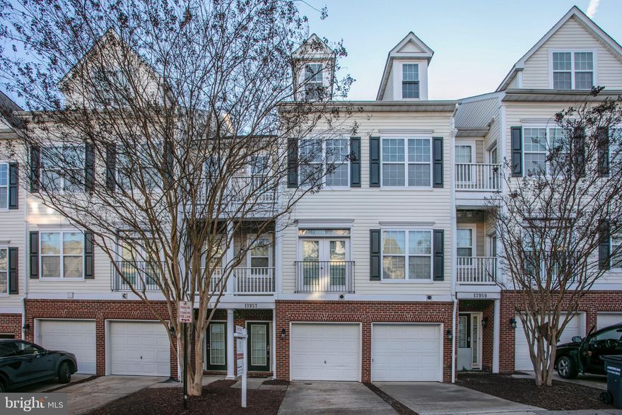 Welcome to 13957 Hollow Wind Way #201. This exquisite townhouse-style condo features three bedrooms and two and a half bathrooms, and is move-in ready with fresh paint and new carpeting throughout. Situated in the highly desirable Commons on William Square community, it offers convenient access to the Prince William Parkway, I-95, VRE, Potomac Mills Mall, and Stonebridge Shopping Center, all just moments away.   The main level showcases a bright, open layout with an updated kitchen that includes ample cabinetry and a pantry for additional storage. The spacious living and dining area, centered around a stunning three-sided fireplace, flows effortlessly into the kitchen. From the living area, you can access a generously sized deck, ideal for entertaining guests.   The primary suite on the main level is impressive, featuring a large bedroom with two walk-in closets, access to a private balcony, and an ensuite bathroom equipped with a soaking tub, separate shower, and double sink vanity. The upper level comprises two additional spacious bedrooms, a bonus or recreation room with large windows that overlook the community, and another full bathroom. Additional features of this property include a private balcony for enjoying tranquil views, in-unit laundry for convenience, and a one-car garage along with driveway parking for your vehicles.