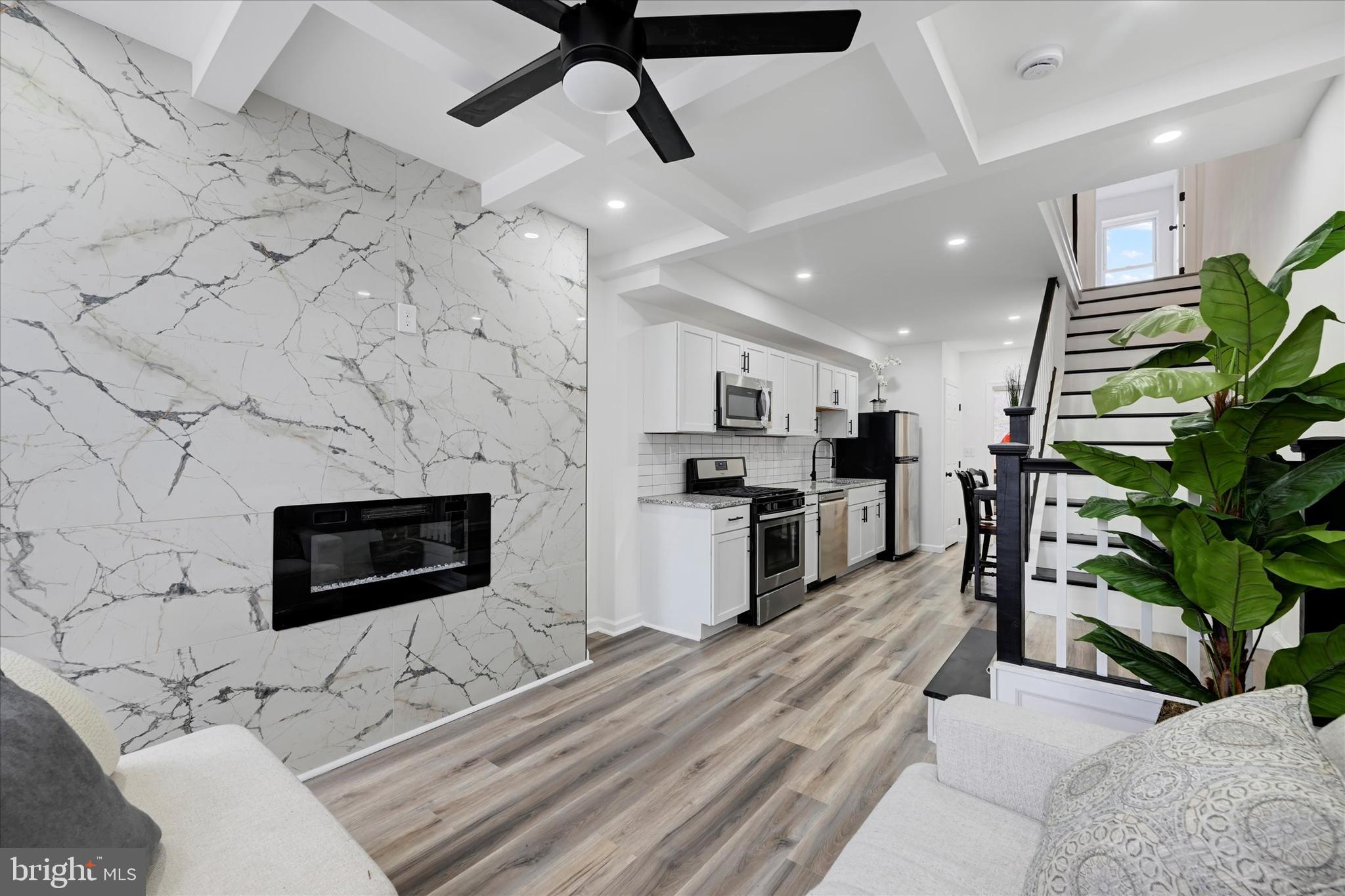 This fully renovated townhome in the desirable Washington Village offers modern comfort and style. The 2-bedroom, 2-bath home features a striking feature wall with a fireplace in the living room and a beautifully updated kitchen with white cabinetry, stainless steel appliances, and a white subway tile backsplash. A bonus space off the kitchen serves as a cozy den or office. The main floor boasts luxury wood flooring, tray ceilings and washer/dryer area for convenience, while the bedrooms showcase tall ceilings with natural & recessed lighting throughout. The lower level is conducive for storage. Both bathrooms are lined in ceramic with contemporary amenities, and the home is conveniently located near all that downtown has to offer such as casinos, ball parks, entertainment, water, close & convenient access to the train station, airport and interstates to surroundings areas such as the Annapolis & DC. Video Tour: https://go.screenpal.com/watch/cZlYVunnWv3