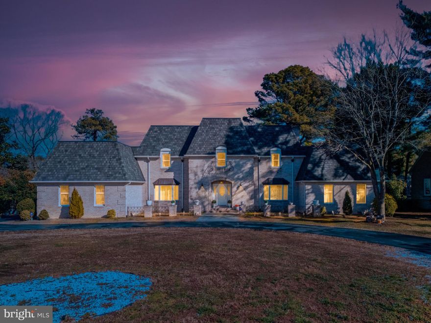 Spectacular waterfront French Provincial chateau ideally positioned on one of the largest lots in Salisbury’s highly sought-after Tony Tank community. Offering breathtaking water views from nearly every room, this timeless residence blends classic craftsmanship with thoughtful modern enhancements. Featuring five bedrooms including a first-floor primary suite and an additional upstairs primary, the home provides exceptional flexibility for both everyday living and guests. The main-level primary retreat boasts a double vanity and a beautifully tiled walk-in shower, while additional bedrooms enjoy serene water views.
Elegant interiors include a mahogany-paneled library with custom built-ins, two wood-burning fireplaces with freshly painted surrounds and recently cleaned chimneys, and expansive windows that frame the stunning waterfront setting. The reimagined kitchen is a true showpiece, equipped with premium Viking, Wolf, and Thermador appliances, a 6-burner gas range, natural stone countertops, and a dramatic waterfall edge. A sun-filled breakfast room opens seamlessly to the elevated stone patio, perfect for indoor-outdoor entertaining overlooking the water.
Recent improvements include a newer 50-year shingle roof, Culligan water treatment system, and approximately 1,000 square feet of newly finished upper-level space with insulation, drywall, carpeting, and walls, ideal for future bedrooms, a media room, or flex space. The fully finished basement features durable vinyl flooring, while the expansive, fully fenced backyard includes a metal fence and a swingset that conveys with the property.
Additional highlights include a circular driveway, two-plus car garage, full-sized T-shaped dock, and generous lot size offering privacy and room to enjoy the outdoors. A rare opportunity to own one of Salisbury’s grand waterfront homes in a premier location, where timeless architecture, modern luxury, and exceptional water views come together.