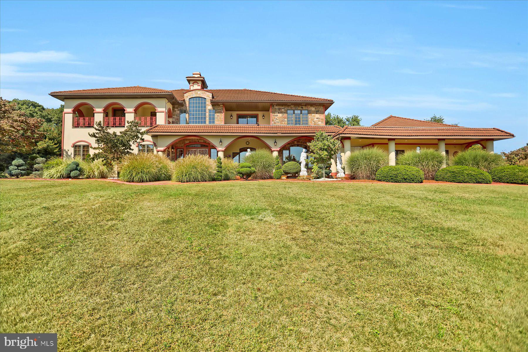 Welcome to this extraordinary Mediterranean-style estate set on over 7 private acres. A long, private lane leads you to this pristine residence, where classic design, elegant finishes, and thoughtful details make it a true one-of-a-kind property. The home’s exterior, finished in elegant Dryvit with stunning pillars and archways, adds to its Mediterranean character and charm. This home was built for entertaining, with multiple gathering spaces including a great room with a wet bar and gas fireplace, a spa room with a large hot tub, and an exercise room (or possible 7th bedroom) with an attached bath and steam sauna shower. The craftsmanship throughout impresses, from solid oak doors and archways to marble, ceramic, and granite finishes. For culinary enthusiasts, the residence features not one but two kitchens. The main chef’s kitchen on the first floor includes a six-burner gas cooktop with built-in grill, double gas Viking ovens, and two pantries—a true delight for any home chef. The second kitchen upstairs offers easy access to the terrace and pool area, making entertaining seamless both indoors and out. Offering 6 bedrooms and 6 baths, each bedroom has access to a balcony, ensuring light, views, and a seamless indoor-outdoor flow. The grand primary suite is a retreat of its own, featuring a jacuzzi, large walk-in closet, and private dressing area, with access to a spacious terrace. Step outside to enjoy the resort-style pool with pool house, outdoor bar, and beautifully fenced yard, perfect for gatherings. Car enthusiasts will appreciate the oversized four-car garage, with one bay offering direct drive-in access to the lower-level basement and wine cellar. The basement itself includes a full bath, ample storage, and dedicated space for a workshop or hobbies. Every aspect of this home, from its arched architectural details to its balconies with sweeping views, was designed to blend comfort with grandeur. With room to relax, entertain, and enjoy, 1164 Grangers Road is truly a Central Pennsylvania paradise.