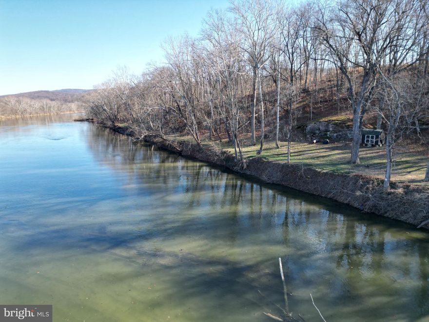 RIVERSIDE PROPERTY WITH MOUNTAIN VIEWS

What better property to own then one with views of the mountains to the east and river to the west? With the elevation change across this property, you can comfortably build while being out of the flood plain and still be close enough to see the water ripple over the rocks.

A convenient road has been cut in from top to bottom to ensure travel down to the river is with ease. Gravel has been placed the full length for those that want to ride a ATV or possibly a vehicle. Once down at the river you are met with large sycamores, oaks and maples that have withstood the test of time  along the banks of the amazing Shenandoah River. A large rock outcrop makes for a fantastic location for a firepit where you can enjoy the sights and sounds. Adjacent to the firepit is a small storage shed for storing those river must haves.

The subdivision of Rock Ferry Station offers common ground derived of a park  and access to the river which is commonly referred to as "the beach". Just a short drive down Mission Road will put you at the Shannondale Springs WMA which offers hunting or hiking opportunities for the outdoor enthusiast. From this property location you are under 13 miles to Charles Town Casino, under 17 miles to Harpers Ferry National Historic Park and under 67 miles to Washington DC.

The property features underground electric and phone line at the front of the property making the connection that much easier. A perc has been completed and a well site has been located closest to the driveway where the large rocks are placed. The hassle of cutting in a driveway has been completed with a culvert in place. A long the property boundary roughly 300 feet from the rivers edge, are orange flags on a post. These flags designate the conservation line in which a house cannot be built beyond without county approval.