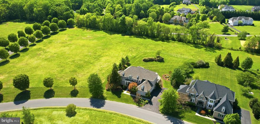 Set in prestigious Red Cedar West, this north facing, four-side brick exceptional Gulick-built Winthrop Manor combines grand scale, timeless architecture, and a rare sense of privacy. Sited on a .73-acre lot surrounded by HOA conservancy land, the property offers an openness and serenity that is increasingly hard to find. With over 8,000 finished square feet, 6 bedrooms, 5 full baths, 2 half baths, and more than $200,000 in recent improvements, showcasing timeless elegance thats designed for both everyday living and elevated entertaining without sacrificing comfort. The exterior is equally impressive with an oversized three-car garage with extra height and a flat, manicured lawn perfectly suited for a future pool. 

Inside, the home opens with a dramatic two-story foyer and sweeping curved staircase that set the tone for the elegant formal spaces beyond. The main level features a gracious living room, a refined dining room with a butler’s pantry, and a striking two-story conservatory. The family room features a gas fireplace and is framed by a wall of windows overlooking the private rear setting, creating a layout that works beautifully for both large gatherings and everyday living. A private home office offers the ideal work-from-home space. Fresh paint, updated flooring, and refined finishes throughout deliver a polished, move-in-ready feel.


The updated gourmet kitchen—truly the heart of the home—seamlessly blends timeless design with exceptional functionality. It features abundant white cabinetry, quartz countertops, a classic subway tile backsplash, and premium stainless steel appliances, including a Sub-Zero refrigerator, double wall ovens, and a professional-grade gas cooktop. A large center quartz island anchors the space, complemented by a serving station—ideal as a coffee or beverage bar—and a separate built-in planning desk. Expansive counter space provides the perfect setting for both everyday meal prep and effortless entertaining.


The kitchen flows beautifully into the breakfast area and sunroom, with direct access to the expansive deck—creating an ideal indoor-outdoor living experience. A convenient rear staircase, along with a  mudroom, laundry room, and two half baths, completes the thoughtfully designed main level.

The upper level offers five generously sized bedrooms, each with walk-in closets. The luxurious primary suite serves as a private retreat, complete with a sitting room and fireplace, dual walk-in closets, and a beautifully updated spa-inspired bath featuring a freestanding tub, frameless shower, and double vanity. Two of the secondary bedrooms include private en-suite baths, while the remaining bedrooms share a well-appointed Jack-and-Jill bath with double sink vanity.


The expansive walk-up lower level features a custom wet bar, multiple recreation areas, a media room, gym, and flexible spaces to suit a variety of needs. An additional bedroom and full bath, along with a third fireplace, enhance comfort and functionality, while abundant storage keeps everything organized. Ideal for entertaining, multigenerational living, fitness, hobbies, or private guest accommodations, this level offers exceptional versatility.

Beyond the home itself, the location adds yet another layer of appeal. Nestled within the sought-after enclave of Red Cedar West—known for its larger estate homes and distinctive setting—this property offers both privacy and convenience. Just minutes from downtown Leesburg, the Dulles Greenway, Dulles Airport, shopping, dining, nearby wineries and breweries, and Loudoun Country Day School, the setting is truly exceptional.
Recent Updates & Improvements
Recent improvements include a new roof (2025), HVAC and furnace (2026), hot water heater (2021), and new carpet throughout the upper level (2026), along with fresh interior paint and updated LED lighting and fixtures throughout the home.