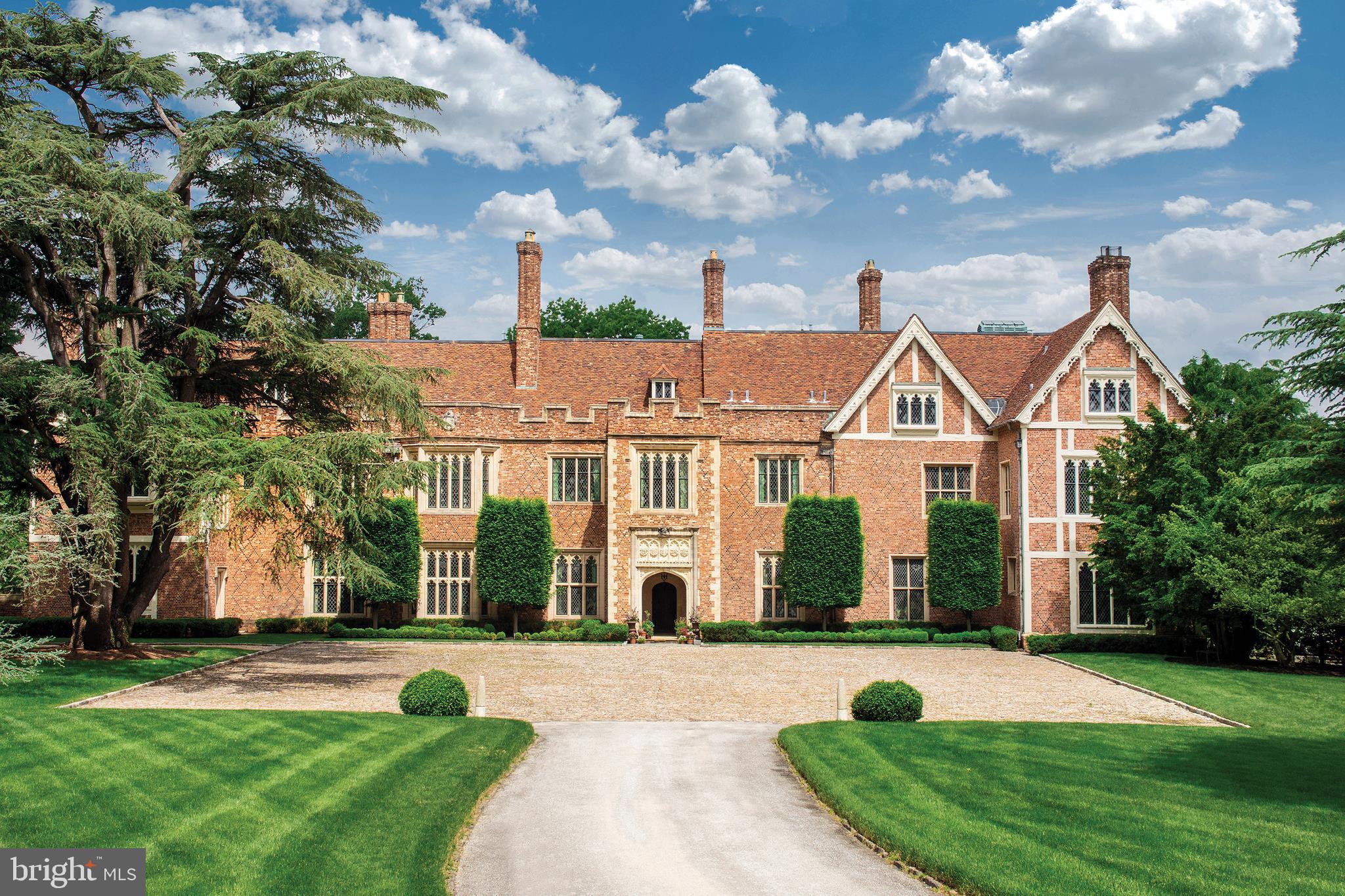 GUILDFORD, a truly rare offering, is an authentic 16th century English Tudor estate majestically situated on 18 park-like acres with sunset vistas and in a world of its own. Down a private lane, one enters through the gates of Guildford and is transported to the English countryside. Inspired by Sutton Place in Surrey, England using architectural elements meticulously imported and reassembled, this breathtaking home took a decade to complete in 1925. Built of reinforced concrete, Guildford's antique brickwork, roof tiles and terracotta window frames need only to function aesthetically. Carved wood paneling, elaborate cornice work, oak floors, limestone walls and stained-glass windows all dazzle as they did when they were originally installed. Upon entering, one experiences the warm majesty of the home. Designed for both elegant entertaining and intimate family life, the interiors are graced with abundant natural light and high ceilings. Past an ancient limestone archway and through an historic carved oak door, the large entry hall greets with a fireplace, linenfold paneling and stone floors. The spacious living room is crowned with ornate molding and centers on a massive fireplace. The Cedar of Lebanon paneled library is an intimate room, perfect for fireside conversations. The garden room with wet bar and tiled floral arranging room overlooks the Great Lawn and sunken garden. The 18th century paneled dining room leads to a butler's pantry and large, light-filled, modern eat-in chef's kitchen. The family and laundry rooms complete the main level. The second floor includes an opulent master suite with 2 luxurious baths and dressing areas and 4 additional en suite bedrooms. The third floor includes 2 charming bedrooms with adjacent studies, large cedar and luggage closets, ample storage, recreation and staff space. The lower level hosts a connoisseur's wine cellar, a spa, staff laundry and multiple storage areas. The home has been completely updated for 21st century living with features that include 2 elevators, 13 working fireplaces (11 wood and 2 gas), a 4-car garage, updated systems, 9 zones of heating/cooling and public sewer. A private and large home office is perfect for working remotely or as a studio. The grounds include woodland trails, pool w/ spa, terraced gardens and a landscaped amphitheater. The property is fully fenced and gated. Very private yet walkable to local train stations, shops, restaurants, galleries and golf / tennis clubs of charming Chestnut Hill. The location also allows for access to some of the areas best private schools, including Springside Chestnut Hill, Germantown Academy and Germantown Friends. Guildford is only a short 25 minute drive from Central Philadelphia and 90 minutes to Manhattan. This is truly a special and magical home not to be missed. Please see Guildford's website https://www.guildfordestate.com for more information and video https://vimeo.com/279515663