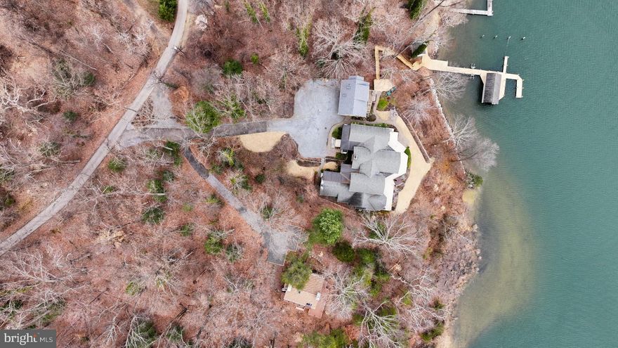 Ideally situated on the banks of Luce Creek with sweeping views down the Severn River, 1715-1717 Porters Hill Road is a unique heritage property with over a century of history. Set on a 2.96 acre lot with 429 ft of waterfrontage, the property is comprised of two separate parcels and includes a large, hard-to-find boathouse that provides both charm and utility for all your waterfront adventures. The private pier has 8+ ft water depth and can accommodate a large vessel as well as an assortment of smaller boats. The tram makes access to the water effortless, and the entire property enjoys exceptional privacy. Steeped in its storied past yet thoughtfully updated for modern living, this retreat captures the perfect balance of historic charm and casual elegance. The heart of the main home is a sunlit great room with original log walls and quarried stone fireplace, a vaulted ceiling, and expansive windows which frame water views at every turn. An adjoining den, with separate entrance option, is a perfect place to relax. This could easily become another main level bedroom with ensuite bathroom. The kitchen is striking under its vaulted ceiling accented by exposed beams. The custom cabinetry and generous island give the space so much functionality while maintaining the artisanal character. The kitchen opens to the dining area overlooking the water. Step outside and you’re embraced by nature: multiple porches and decks overlook lush, manicured grounds that lead down to the water’s edge. The main-level primary suite is a true sanctuary, designed for privacy and tranquility. The bedroom, with a vaulted ceiling, has a screened porch overlooking the water. Two expansive walk-in closets offer custom organization systems that would make a clothing connoisseur smile. The spa-like bathroom gets lots of natural light from the windows that frame the water, and the freestanding soaking tub is situated to enjoy this view. A dual-sink vanity, heated floors, and generous walk-in shower with a built-in bench make getting ready feel effortless and luxurious. A dedicated laundry area just off the hallway makes day-to-day living very easy. Part of the primary suite is a gracious office with gas fireplace and outdoor access. This is a totally flexible space: install a wall of bookshelves and you’d have a lovely library. Upstairs, there are two generously sized bedrooms. One has water views and a waterside balcony; the other overlooks the lush landscaping out front. There is a hall bathroom. A separate guest bedroom suite above the garage, complete with its own living area and luxe bathroom, is ideal for visiting friends and family who desire more privacy. The second home, on the 1717 lot, offers a contemporary setting with clean lines and spacious deck. The dramatic two-story family room facing the kitchen means tons of natural light for the entire house. The main level has a bedroom and full bathroom, and there are two more bedrooms upstairs that share a hall bath. The walk-out lower level features a rec room and a large utility/storage area.

The Historical Context: Originally built in the 1880s, the log house on 1715 was one of three identical structures used as hunting lodges. It is the only one that remains. The construction of the log house is one of great craftmanship, including sizing each log to be approximately the same diameter as others. It's amazing that 1715-1717 has such easy access to downtown Annapolis by car or boat, and for those who commute to DC or Baltimore, Route 50 is less than 10 minutes. This incredible heritage property, encompassing almost three acres, two dwellings and a deep-water pier with boathouse, is the ultimate Annapolis retreat.