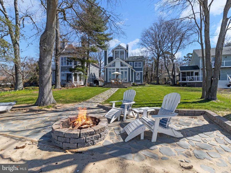 Absolutely sensational water views from a beautiful coastal style home overlooking Fishing Creek.  Vacation all year long in this ideal Annapolis location, just off the Chesapeake Bay.  Enjoy sunsets every evening on your beach or from your cozy family room with floor to ceiling windows. Double French doors lead from the family room to a large private stone deck for effortless waterside enjoyment. Walk along the grassy lawn to easily launch your kayak, paddleboard or sailboat from the beach.  The interior of the home is designed to take full advantage of indoor/outdoor waterside living and entertaining. From the moment you walk into this lovely home, you are greeted with panoramic views that have year round interest through boating activity, wildlife and the changing of the seasons. The interior is bathed in sunlight with freshly painted walls that blend seamlessly with the vaulted ceilings and custom trim. The contemporary open floor plan still allows for separate spaces to be enjoyed throughout the home. The main level features many custom built-ins, a cozy fireplace, large kitchen, dining and family room. There is also one bedroom on the main level with full bath, mudroom and side entry. The second level includes the primary bedroom with large bath and its own separate reading nook, compete with an additional fireplace and view to the family room. The third floor is exceptional with two large floor to ceiling windows, vaulted ceilings and skylights. This space is ideal for an additional family room, office, Peloton space, kids play area or fourth bedroom. There are so many recent improvements including freshly refinished wood floors on the main level, brand new dishwasher, newer hot water heater, newer washing machine, newer HVAC (2018), furnace (2019) and roof replacement (2011). Store all your treasures, gardening gear and boat supplies in the tidy, oversized shed and park several cars on the paver-parking pad.  The subject property is non-riparian and does not require flood insurance. Conveniently located just minutes from downtown Annapolis and Eastport in the desirable neighborhood of Arundel on the Bay. The community offers a beach, pier, boat launch and many activities. Bike or stroll through the neighborhood as you greet friends and neighbors. This is every water lovers dream with easy access to Annapolis, The Eastern Shore of MD and Washington DC. Welcome Home!