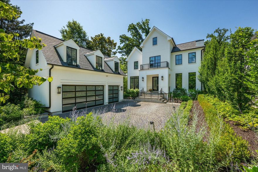 New Offering! An architecturally distinct residence with resort-caliber grounds located in Woodmont, one of North Arlington’s most established and sought-after neighborhoods—just one light from Washington, DC—this 7,000+- sqft home was custom built in 2018 by Brush Arbor Homes, in collaboration with Francis Fetzer Architecture. Framed by landscaped grounds and anchored by a resort-style pool, the home is defined by thoughtful architecture, enduring materials, and a seamless integration of refined interiors with outdoor living.

The main residence reflects a deliberate commitment to quality and proportion, with a floor plan that balances formal definition and everyday ease. 6 bedrooms, 6.5 baths, and an elevator are complemented by high ceilings, wide-plank white oak floors, and carefully composed transitions between living spaces. A detached three-car garage introduces a private one-bedroom, one-bath apartment above—an uncommon and highly versatile addition well suited for guests, extended family, or au pair living.

The rear grounds unfold as a private retreat, where mature landscaping frames the pool, covered porch, fire pit, and putting green—an outdoor environment designed for both entertaining and quiet enjoyment, moments from Clarendon and Washington .

The main level is anchored by two elegantly scaled rooms that allow for flexibility in use: a moody library with custom built-in shelving that may also serve as a formal living room, and a refined dining room that can easily function as an additional gathering space. A discreet butler’s pantry and a thoughtfully designed mudroom with side entry complete the level.

At the heart of the home, the kitchen is both architectural and functional, featuring custom cabinetry, premium appliances, and an expansive island that opens naturally to adjacent living and dining areas. These spaces extend effortlessly outdoors, reinforcing the home’s connection between interior comfort and exterior living.

The second level is centered around a serene primary suite, offering a private balcony overlooking the pool and rear grounds, generous walk-in closets with custom organization, and a spa-like bath with steam shower. Three additional en-suite bedrooms and a laundry room complete the level.

Above, the fourth level provides flexible living space with two bonus rooms and an additional en-suite bedroom—ideal for teen hang-outs, guests, or a private office.

The lower level is designed with both leisure and wellness in mind, featuring a recreation room, full bar, craft room or office, an additional en-suite bedroom, and a fully equipped gym with mirrored walls and rubber flooring. A walk-up stairwell offers direct access to the side yard.

This Woodmont residence stands as a composed and enduring offering—where architecture, craftsmanship, and landscape converge to create a home of quiet distinction in one of Arlington’s most desirable neighborhoods.