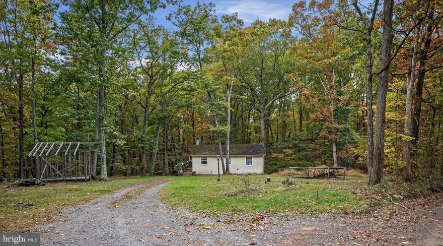 Indulge in the serenity of this secluded one-bedroom, one-bath home nestled on
a sprawling 5+ acres of outdoor seclusion. This cozy escape has been lovingly
updated to offer you the utmost in comfort. Recent updates include a remodeled kitchen with new appliances, new LVP flooring and fresh paint. As you step onto the expansive wrap-
around deck, you'll be greeted by a picturesque stream that runs through the
property. Immerse yourself in the tranquil ambiance and when the evening chill sets in,
warm yourself by the inviting fireplace. And if you're a nature enthusiast or an
angler at heart, a charming fishing pond (with community access only) is just a stone's throw away and Cacapon River is just 2 miles away. This could be the country road that takes you home!