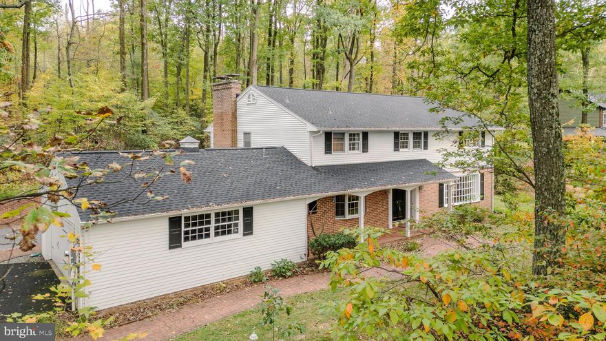 Nestled on the mountainside and surrounded by trees and native wildlife, this sprawling Colonial two-story home offers the perfect blend of peaceful seclusion and spacious comfort. With over 4,500 square feet of thoughtfully designed living space, this retreat features 4–5 bedrooms and 4 full bathrooms—ideal for multi-generational living or hosting guests.

A grand two-story foyer with a turned staircase welcomes you inside, setting the tone for the home's warm and elegant character. To one side, a bright and expansive living room showcases rich oak hardwood floors and an abundance of windows, offering panoramic views of the wooded surroundings. Opposite the foyer, a private study or optional main-level bedroom includes custom built-ins and is conveniently located next to a full bathroom—perfect for guests or flexible use.

At the heart of the home, a French country-inspired kitchen features crisp white cabinetry, wood countertops, charming tile backsplash, brick accent walls, and a spacious breakfast area. The kitchen flows seamlessly into an intimate family room with a cozy wood-burning fireplace, creating the perfect gathering space. For more formal occasions, the elegant dining room is appointed with crown molding, chair rail, and hardwood flooring.

Upstairs, you'll find four generously sized bedrooms and three full baths. The primary suite is a true retreat with its own gas fireplace and a private ensuite bath. A second bedroom also enjoys an ensuite bath, while two additional bedrooms share a well-appointed hall bath. A finished bonus room on this level provides ideal space for storage, a hobby room, or future second-floor laundry.

The finished lower level offers additional living or recreational space, adaptable to your needs.

Step outside to a serene paver patio featuring yet another wood-burning fireplace—an inviting spot to relax and take in the sights and sounds of nature year-round.

If you're seeking a one-of-a-kind mountain retreat with timeless charm and room to grow, look no further.