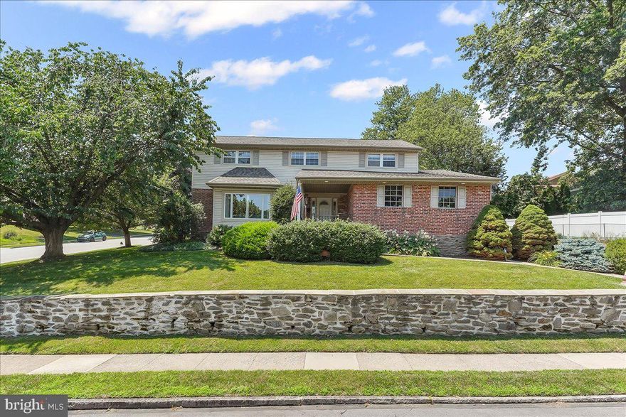 Welcome to this beautifully maintained Colonial home offering 5 bedrooms, 3.5 baths, and in 2345 sqft of thoughtfully designed living space. Nestled in the heart of Springfield Township, this home combines timeless charm with modern updates and exceptional functionality. Step onto the inviting covered front porch and into a spacious foyer with a coat closet. The sunlit living room features a large picture window and a cozy gas fireplace framed by a classic mantel. Hardwood floors and updated crown molding flow through the main level, adding warmth and character to each room. The formal dining room leads to a tastefully updated kitchen, complete with granite countertops, gas stovetop, built-in microwave, a dishwasher, recessed and under-cabinet lighting, and a convenient laundry area. Recently refaced cabinets, new drawers, and upgraded hardware bring a fresh, modern touch. Just off the kitchen, a large den with a powder room provides the perfect space for relaxing. You'll love the expansive mudroom with abundant closet space to keep everything organized, from coats and boots to sports gear and weekend essentials. From here, access the paver patio, oversized two-car garage, and spacious driveway. Upstairs, the spacious primary suite includes a walk-in closet and a newly renovated en-suite bath with a double stone-top vanity and tiled corner shower. Three additional bedrooms share a bright hall bath with colorful tile. A fifth bedroom at the end of the hall serves as a junior suite with ample closet space and its own full bathroom—ideal for guests or multi-generational living. Note that hardwood floors are under the carpet on the second floor. The fully finished basement offers even more living space, perfect for entertaining or hobbies. Custom built-in shelving and a cedar closet provide excellent storage. Outside, enjoy a wide paver patio and a ready-to-use playset. Additional features include replacement windows, gutter helmets, Central air, and a low-maintenance yard. Don't miss your chance to own this move-in-ready home with room for everyone and everything. The home has been pre-inspected for informational purposes only.