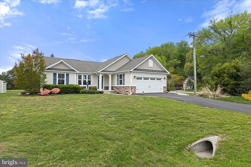 This beautifully appointed corner-lot home, originally the model for the community, showcases thoughtful design, quality finishes, and a picturesque setting surrounded by mature trees and landscaping. A lawn irrigation system keeps the grounds lush, enhancing the home’s exceptional curb appeal.

Inside, a neutral coastal palette and open-concept layout create a light, inviting atmosphere. The kitchen, living, and dining areas flow seamlessly together, ideal for both everyday living and entertaining. The kitchen features crisp white cabinetry, granite countertops, stainless steel appliances, a center island with breakfast bar and pendant lighting, and recessed lighting throughout. Sliding glass doors lead to the screened porch, extending the living space outdoors. The spacious living room is anchored by a cozy gas fireplace flanked by windows that fill the space with natural light. The dining area is equally bright, highlighted by crown molding, chair rail detailing, and an abundance of windows.
A desirable split floor plan offers privacy and flexibility. Two guest bedrooms and a full hall bath are tucked behind a stylish barn door, creating a private retreat for visitors. On the opposite side of the home, the primary suite features a generous walk-in closet and an en suite bath with granite countertops. Just off the kitchen, a functional mudroom area includes a built-in bench, storage, and coat hooks, along with access to the garage. Additional highlights include a laundry room and an encapsulated crawlspace with a dehumidifier and sump pump for added peace of mind. Outdoor living is equally inviting, with a screened porch and adjoining paver patio overlooking a tranquil pond and fountain. Whether enjoying a quiet morning coffee or unwinding by a fire pit in the evening, this space offers a serene backdrop for relaxation.

Residents of Fox Haven enjoy a variety of community amenities, including a clubhouse, swimming pools, boat and RV storage, scenic walking paths, low HOA fees, and low property taxes. All of this is complemented by a convenient location just a short drive from area beaches, shopping, dining, and popular coastal attractions.

Blending model-home quality, thoughtful upgrades, and a scenic setting, this residence offers comfort, style, and a true connection to its natural surroundings.