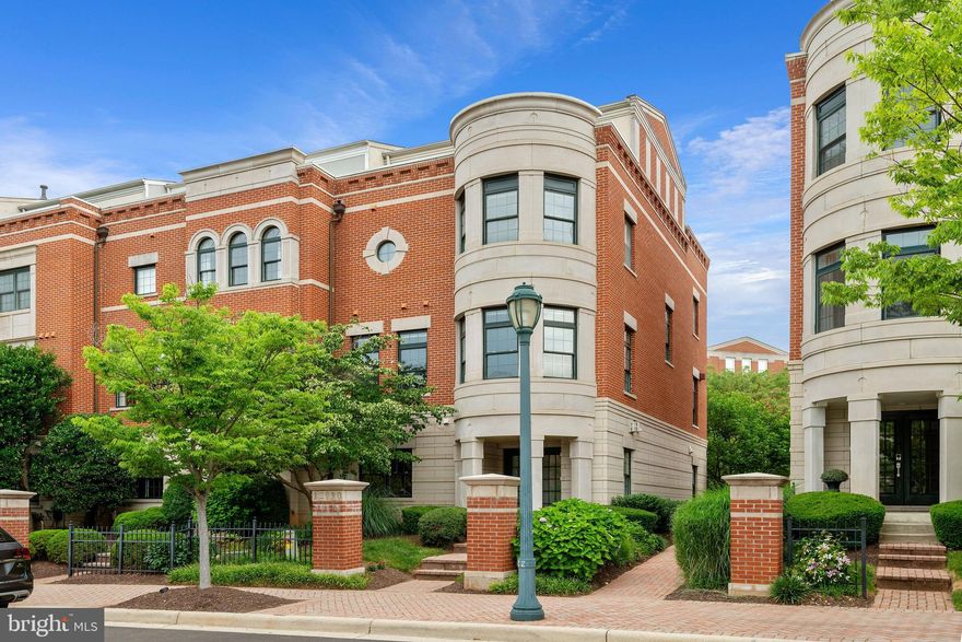 Beautiful and rarely available end-unit London-model townhouse in West Market in Reston Town Center. This upscale neighborhood of Georgian-styled townhouses was inspired by Chicago and has an urban feel.  The gracious foyer on the entrance level leads to the library with custom built-ins and fireplace, a powder room, access to the 2-car garage, and rear entrance. The main level has a gorgeous renovated and expanded kitchen with floor-to-ceiling windows, top-of the-line appliances, large center island that opens to the breakfast area and family room with built-ins and fireplace. The main level also includes a bright and open 24-foot wide living-dining room with a bay window overlooking the manicured gardens of Market St.  The third level boasts the grand and private Owner’s Suite with an elegant bathroom and two large custom walk-in closets. Also on the main level is a sun-lit second en suite bedroom as well as the washer and dryer. The stunning penthouse on the fourth level is complete with custom built-ins, wet bar, beverage fridge and fireplace. The penthouse retreat opens to a large roof terrace with beautiful views and has a convenient gas-line hookup. This home offers audio throughout four floors, three fireplaces, sprinklers, and much more