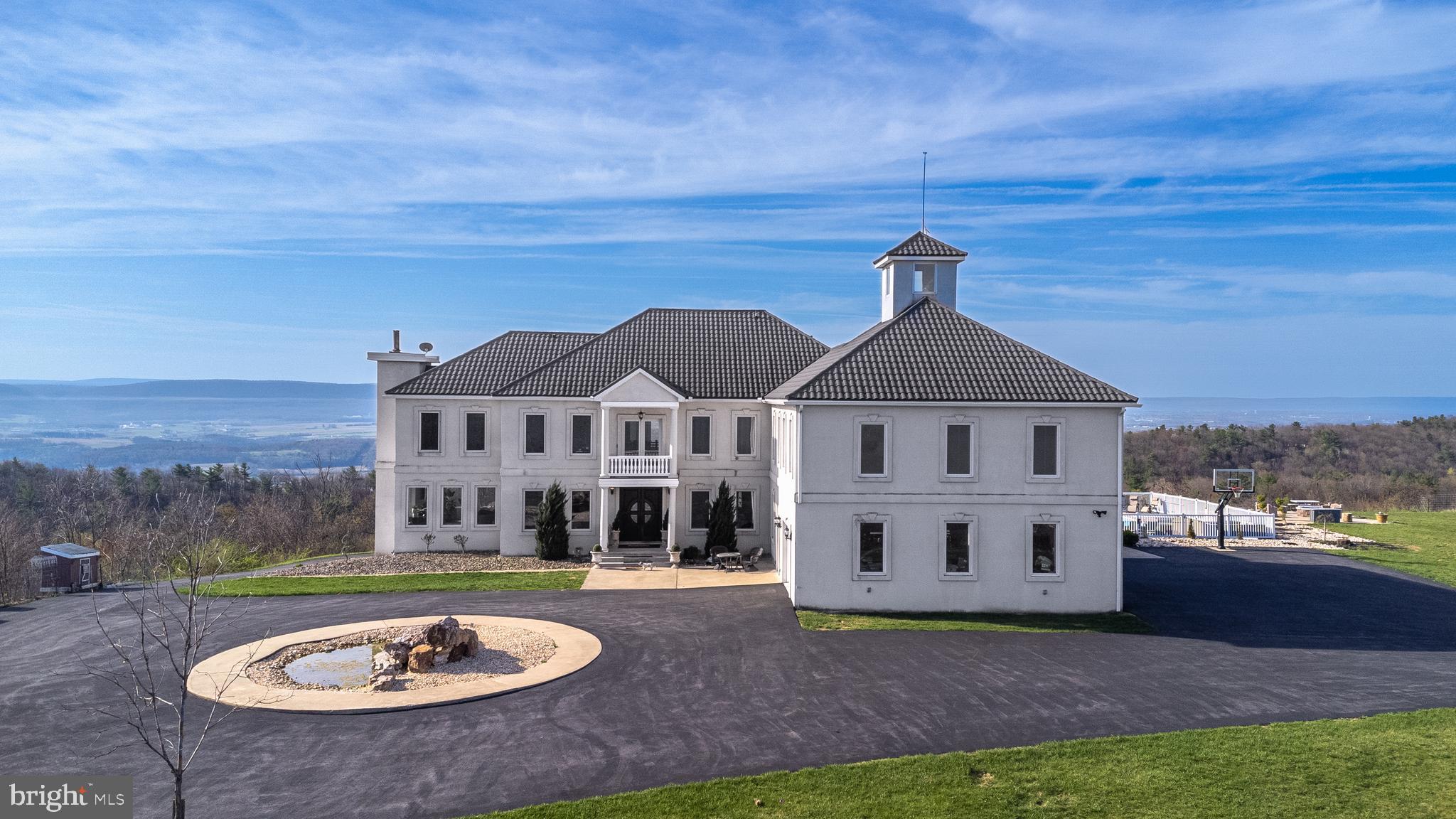 Luxury Mountain Estate with Unmatched Amenities Near Penn State: A stunning 5-bed, 6.5-bath mountain-top estate on 35 secluded acres, offering over 7,800 sq ft of finished interior space. Built with ICF construction, featuring geothermal heating and a backup generator, it provides an efficient, durable, and off-grid capable lifestyle. Enjoy a chef’s kitchen, walk-in closets, spa tubs, a large pool, a barn, oversized garage spaces, and more. Experience mountain living just minutes from Penn State University. Schedule your private tour today.
Additional Amenities
- 20x40’ pool & spacious deck
- 60x40’ barn
- Oversized 4-car garage with RV bay + basement garage
- 400-amp electric supply
- Lifetime stone-coated Spanish-style metal roof
- 600’ well with 1,000-gallon basement water holding tank with softener
- 1,000-gallon buried rain collection system
- Full off-grid capability with dual manifolds and hot water tanks
- 1,000-gallon buried propane tank
- Dual laundry facilities
**Showings require verified proof of funds or a pre-approval letter.**