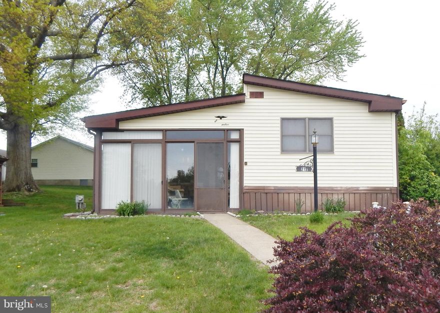 One of the best locations in Neshaminy Falls over 55 Community!!  Front porch, large lot, additional den with french door and deck on the back.   This 2-bedroom, 2 Full-bath manufactured home is ready for your personal touch. Perfect for those looking to customize and create their own space, this home offers great potential with one of the largest homes in the neighborhood, a spacious layout and convenient single-floor living.  Three season porch in front, dining room, master bath, slider to the deck in the back. Situated in a quiet, large lot with space for a garden, a gazebo and a shed.   Motivated seller and a property being sold as-is.