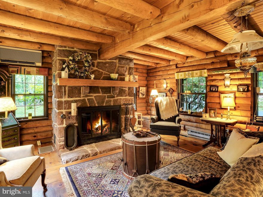 Welcome to another world!  This beautiful log home is situated in the middle of a 20-acre woodland at the crest of a gentle hill, truly a sanctuary surrounded by nature.   At the end of the private drive, a covered porch invites you into a large living/dining room, with stone fireplace and wide-planked pine floors.  An eat-in kitchen with custom-made cherry cabinets, a vaulted den with wood-burning stove, and full bath complete the first floor.  The amazing staircase in the den leads to a cozy balcony and two 2nd floor bedrooms, one with a spectacular bank of windows looking out into the woods.  The ground floor has two more bedrooms, both opening into a sunroom, a full bath and laundry, and a large workroom/shop.  The master bedroom has a propane log set, perfect for winter nights.  Covered porch and open-air decks on the rear of the house provide great spaces for relaxation, gathering and entertaining.  A large detached garage, with full second floor, has plenty of space for storage and activities.  This owner-built home has been upgraded and beautifully maintained.  As a designated “Clean and Green” property, it also enjoys a reduced tax rate.