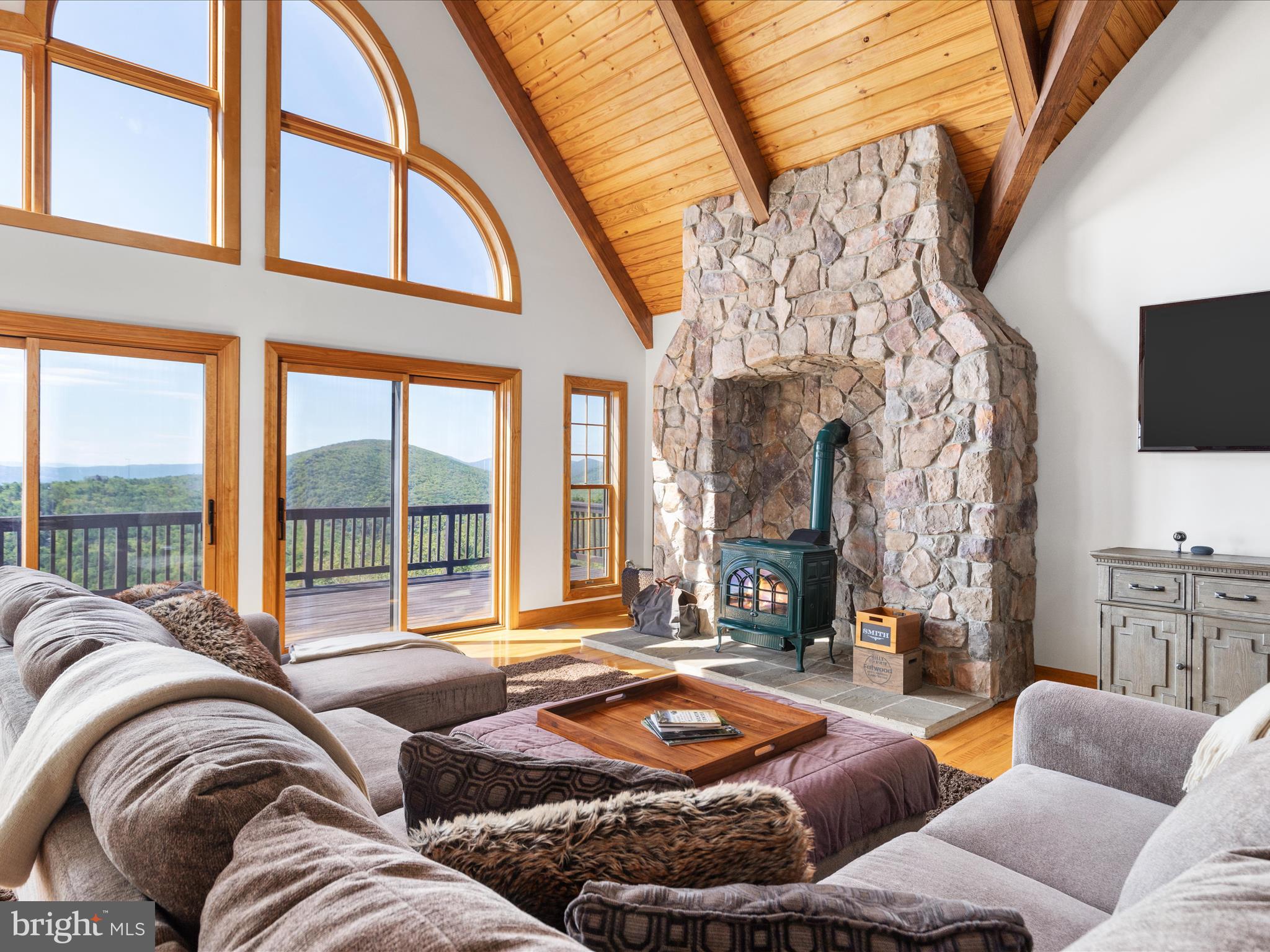 Nestled atop the Great North Mountain, this mountaintop retreat offers unparalleled, breathtaking panoramic views. Truly a rare combination of privacy, seclusion, and stunning natural beauty perfect for those seeking a true connection with nature. Situated just west of Stephens City, it is bordered by Short Mountain to the south and Eagle Rock to the north, providing unmatched views of the surrounding mountains and valleys. This fully wooded estate extends to the summit of North Mountain, offering end-of-the-road privacy, private access to the Tuscarora Trail, and endless opportunities for hiking, horseback riding, camping, and outdoor recreation. The property trails are fully accessible and run along the entire length, allowing for uninterrupted exploration and hunting.
The spacious lodge boasts nearly 2,500 square feet of living space, including three bedrooms, three full bathrooms, and an unfinished walk-out basement that is fully plumbed for a 4th bathroom. At the heart of the home, the great room features cathedral ceilings, a woodstove, and a loft overlooking the space below. The expansive kitchen, complete with an island, opens to a sunroom equipped with a wood burning fireplace, perfect for entertaining or enjoying quiet mornings in nature. The property also includes a 20 ft x 40 ft pole barn, providing ample storage for gear and equipment.
Residents of this gated community enjoy secure access via Great Mountain Lane, requiring a 4-wheel or all-wheel drive vehicle to reach the property. The western boundary of the estate is marked by the Virginia-West Virginia state line, and the land is rich with wildlife, including deer, turkey, and bear. A small mountain stream flows through the property, adding charm to the landscape. Short-term rentals are allowed, presenting an excellent investment opportunity. Additionally, the property can be subdivided into 20-acre lots, offering future development potential. Furniture and household items are conveyed with the sale of this property.
Zoned RA and enrolled in the county’s Forestry Land Use program, this property is ideal for those seeking both a private retreat and a sustainable investment. Despite its secluded location, it is only a short drive from Winchester's amenities and attractions, as well as the nearby Capon Springs Resort. Equipped with Starlink Internet, the property combines the best of remote living with modern convenience. This is not just a home—it's an escape from the hustle and bustle of everyday life. Whether you’re looking for a weekend retreat, a full-time residence, or a place to reconnect with nature, this mountaintop property offers the perfect blend of seclusion and modern comforts.
*An extensive list of personal property is also available for purchase; contact the agents for details