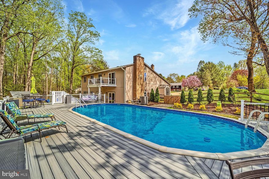 Entertainer's Dream with Heated Pool! Welcome to your completely updated custom split-level home with over 2,700 sq ft above grade nestled on a picturesque 1.13-acre cul-de-sac lot backing to trees for privacy and amazing views to enjoy from your pool deck & the deck off your primary bedroom suite! This home offers modern charm and thoughtful design through a meticulous transformation that showcases a beautiful combination of hardwood floors, soaring ceilings, modern finishes, fresh paint, and ceramic tile floors.  This one-of-a-kind property also includes an entertainer's dream backyard complete with new hardscaping, landscaping, new composite pool deck with heated pool complete with 20yr warranty, all sited on one the best lots near the end of a cul-de-sac in the desirable subdivision of Huntington in Fallston. The freshly landscaped exterior invites you into the open main level, where you have a spacious bonus room with cathedral ceilings suitable to serve as an additional family room or bonus room. The gourmet kitchen boasts new kitchen cabinetry, gleaming countertops, stainless steel appliances & opens up to the family room and walk-out patio. The family room level also offers an additional 5th bedroom for guests or flex space. Up a half flight of stairs from the main level, the bedroom level awaits. The spacious upstairs offers 4 bedrooms with an amazing primary suite featuring a spacious bedroom, walk-in closet space, and a spa-like en-suite bath.  The best part of this primary suite is your own private composite deck leading out to enjoy your morning coffee overlooking the acre plus of landscaping and mature trees. Three additional bedrooms complete the upper level, sharing an updated full hallway bath. The main lower level includes a spacious family room with a cozy wood burning fireplace, a half bath, and patio access. Outdoor living shines with a new composite pool deck, a heated pool, and spacious fully fenced yard backing to mature trees for ultimate privacy and enjoyment complete with a new 12x14 shed with electric. The home features updated mechanicals along with a new roof, new gutters, all new windows & much more. Located near everything Fallston has to offer, in Fallston School district, this stunning home offers the ideal combination of modern luxury with unmatched outdoor living in the most tranquil setting.