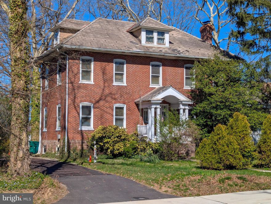 Step back in time with this stately 1899 brick Colonial, a true grand dame of East Main Street awaiting its next chapter. Rich in character and architectural detail, this home offers timeless charm with the opportunity to restore and reimagine for modern living. Situated on a generous 0.8-acre lot directly across from Memorial Park, the setting is as special as the home itself.

Inside, the first floor showcases a gracious foyer, stunning original woodwork, a spacious living room with wood-burning fireplace, formal dining room, heated sunroom, kitchen, butler’s pantry, and a convenient powder room. Upstairs, you’ll find three good-sized bedrooms and a full bath, along with an additional room ideal for creating a primary suite bath. The primary bedroom also features a private enclosed porch. The finished third floor offers flexible space for a home office, studio, or additional living area. Full basement provides ample storage.

While the home is fully functional, it does require updates, including a new roof, and is ready for a buyer with vision to restore its former grandeur. Detached garage and outbuildings are in need of repair, but the expansive lot offers incredible potential for outdoor living and landscaping.

Enjoy an unbeatable location—walk to Memorial Park and sports fields, stroll into vibrant downtown Lansdale for shopping and dining, and just a half mile to the Lansdale SEPTA commuter rail station. Located in the award-winning North Penn School District.

Offered at a price below its recent as-is appraisal, this is a rare opportunity to own a piece of Lansdale history and create something truly special.