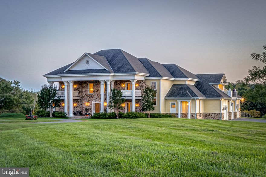 Significant price reduction, Fauquier County tax assessment is $2,244,100.  On the DC side of Warrenton, this impressive custom-built 7,700 square foot home is located on 8 private acres surrounded by scenic vistas.  The main level has a grand entry foyer, ground floor owner suite, and an attractive open kitchen with double ovens, 2 dishwashers, a large farmhouse sink, granite counters, and custom cabinetry.  The kitchen is open to the family room with a large Rumford fireplace and a light filled conservatory with a second Rumford fireplace and rough-in for a bar.  There are also formal living and dining rooms, a built-in office, and a mudroom on the main level as well as laundry on each floor.  The entry foyer has 24-foot ceilings, and the home has 14-foot ceilings on the main level with custom crown moldings generously sized throughout and a mix of Brazilian cherry hardwood floors, marble, and travertine tile in the conservatory.  The front door is a customized design imported from Argentina.  The primary suite is conveniently located on its own wing with a gas fireplace, elevated sleeping area, two closets, and a large bathroom with 2 sinks, separate water closet, expansive shower with 2 shower heads, and heated flooring.    There are 4 additional large bedrooms upstairs each with an en suite bathroom and private balcony for individual outdoor space.  The upstairs bedrooms are connected by 2 sitting areas, one of which is roughed in for a wet bar.  There is electrical work installed behind the house for a pool in an ideal location surrounded by patios, an outdoor fireplace, half bathroom, and outdoor shower.  The circular driveway entrance has established landscaping and water fountain with an oversized 3-car garage on the side.  There are two 1-acre fenced pastures with a run-in shed for animals of any breed or size.  The property is surrounded by land in a conservation easement with 4 estate lots.  The home is built of high-quality construction.  Ideal location 30 minutes to Dulles airport and 45 miles to Washington DC.  Property is surrounded by horse farms with an abundance of wildlife to enjoy.