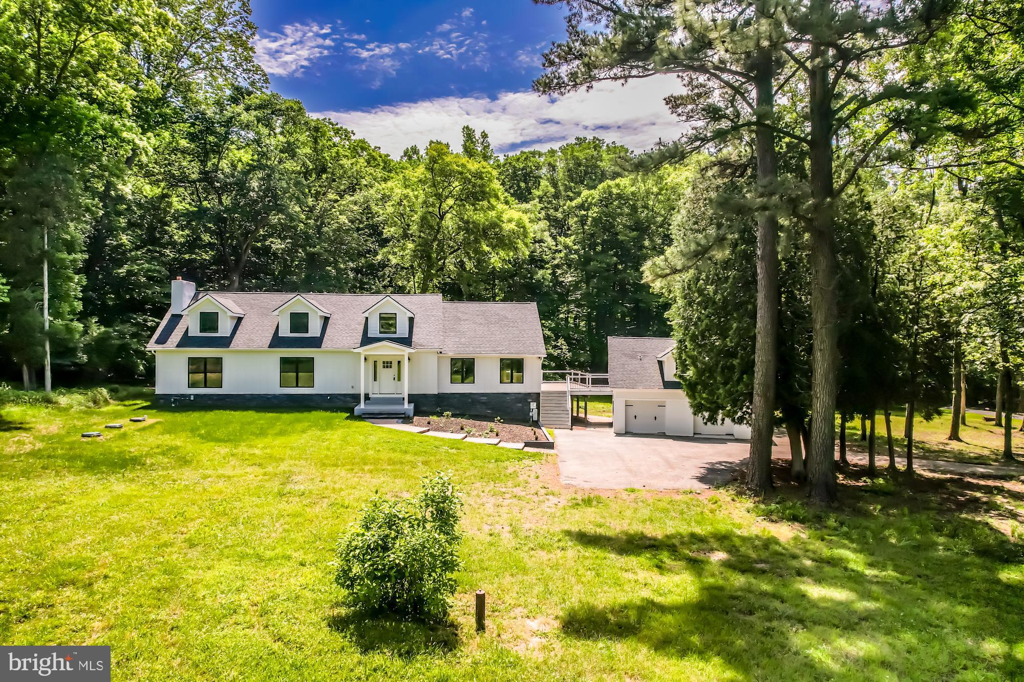Welcome to the impeccably reimagined cape cod nestled in the scenic rolling hills of Landenberg at 258 Mercer Mill Road. Every detail has been carefully redesigned from the foundation to create a home that merges durability with aesthetic appeal. Key upgrades include a new 40-year architectural roof, luxury Marvin brand windows and doors, and hardy board siding in a classic black and white palette that exudes timeless elegance.
Stepping inside, the main level impresses with stunning hardwood floors and a striking gourmet kitchen with 20-foot ceilings, custom timber framing, and wood cladding. Equipped with top-of-the-line Thor appliances and beautifully crafted cabinetry in sage green and off-white, this kitchen is a chef’s paradise. Adjacent to the kitchen, a new composite deck connects to an above-garage in-law suite, offering nearly 1000 square feet of versatile space complete with a full bath and multiple closets.
To the left of the main entrance, the spacious formal living room opens through French doors to a breathtaking primary suite, beginning with a cozy office featuring a wood-burning stove. The suite continues into a generously sized bedroom with large windows and flows into an exquisite primary bathroom with a massive rainfall shower, soaking tub, hardwood double vanity, and heated floors. A vast walk-in closet with custom-built ins completes the suite.
Upstairs, a secondary living space features luxurious multi-tone Karastan carpets and large windows overlooking the backyard. Each bedroom on this level boasts ample space and its own unique bathroom, enhancing creativity and comfort. The fully finished basement includes two additional bedrooms with a shared custom Jack-and-Jill bathroom and a warm, inviting living area finished with high-end, wide plank wood faced tile.
Situated on 3.75 acres of wooded land with a creek meandering through, this property offers the perfect retreat for nature lovers seeking privacy. All dead trees have been thoughtfully removed and the yard has been seeded with high-end grass, ensuring a lush and vibrant landscape.
Don't miss the chance to own this unparalleled property, ready for you to live in and love.