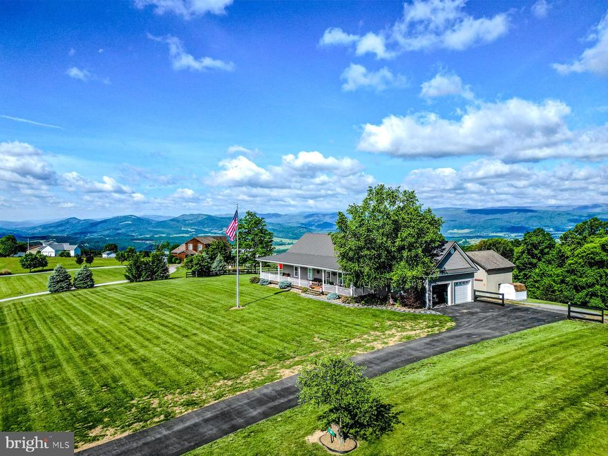 Perched on 2.08 acres, high atop the ridge in the highly sought-after Orchard View Estates Subdivision, this custom-built home by D&T Builders delivers exceptional craftsmanship, energy efficiency, and jaw-dropping views from nearly every angle. Boasting 2,300 square feet of thoughtfully designed living space, this 4-bedroom, 2-bathroom residence offers a warm, open-concept floor plan that perfectly blends everyday function with elevated mountain living.

Inside, you'll find rich hardwood floors, 9-foot ceilings, and a seamless layout that includes main-floor laundry, a spacious walk-in pantry, and wide 36” interior doorways for added accessibility. The heart of the home flows effortlessly from the kitchen into the dining and living areas—ideal for entertaining guests or enjoying a quiet evening at home. Upstairs, a large fourth bedroom offers privacy and comfort with its own dedicated 24,000 BTU heating and cooling system separate from the main floor, plus supplemental baseboard heat. This upper-level space is also plumbed for a future bathroom and kitchenette, making it the perfect option for an in-law suite, guest quarters, or home office.

The partially finished walkout basement features heated and cooled living space, durable poured concrete walls, and a cozy wood stove—offering even more room to expand or customize. The home was built with 2x6 exterior walls and extra insulation, topped with a new metal roof installed in 2022, and wrapped in insulated siding for year-round efficiency. All copper hot and cold water lines, pocket doors throughout, hardwired security cameras, and a massive 400 amp electrical service speak to the quality and care built into every inch of this home.

The oversized, insulated two-car attached garage is ready for all your needs, while a 30 amp RV plug is conveniently located beside both the garage and the 24’x24’ two-story shop, which includes its own wood stove, concrete flooring, and 100 amp service—perfect for projects, storage, or hobbies. The blacktop driveway adds convenience and curb appeal, but what truly sets this home apart is the setting.

Step out onto the expansive wrap-around covered deck with low-maintenance vinyl railings and take in the awe-inspiring views of the surrounding mountains. It’s the ideal place to watch the sunrise with a cup of coffee and wind down at sunset with a picture-perfect Instagram moment. At night, gather around the fire ring with friends and family to relax under a blanket of stars.

Located just five minutes from town, you’ll have easy access to restaurants, grocery stores, gas stations, parks, the public pool, and river access for boating and fishing. Need to shop? It’s only 20 minutes to Walmart in Moorefield, 1 hour and 30 minutes to Winchester, Virginia, or just 10 minutes more to Harrisonburg. Looking for adventure? You're within reach of West Virginia’s most scenic spots—50 minutes to Blackwater Falls, 40 minutes to Dolly Sods Wilderness, 35 minutes to Seneca Rocks, and 2 hours to Snowshoe Mountain Ski Resort. Even the D.C. Beltway is just over two hours away.

This home offers the rare combination of modern construction, premium features, privacy, and location. Whether you’re looking for your forever home, a family retreat, or a mountain getaway with potential for multi-generational living, this one-of-a-kind property is ready to impress. You don’t just buy a home here—you buy the view, the peace, and a lifestyle worth living - start living it today!