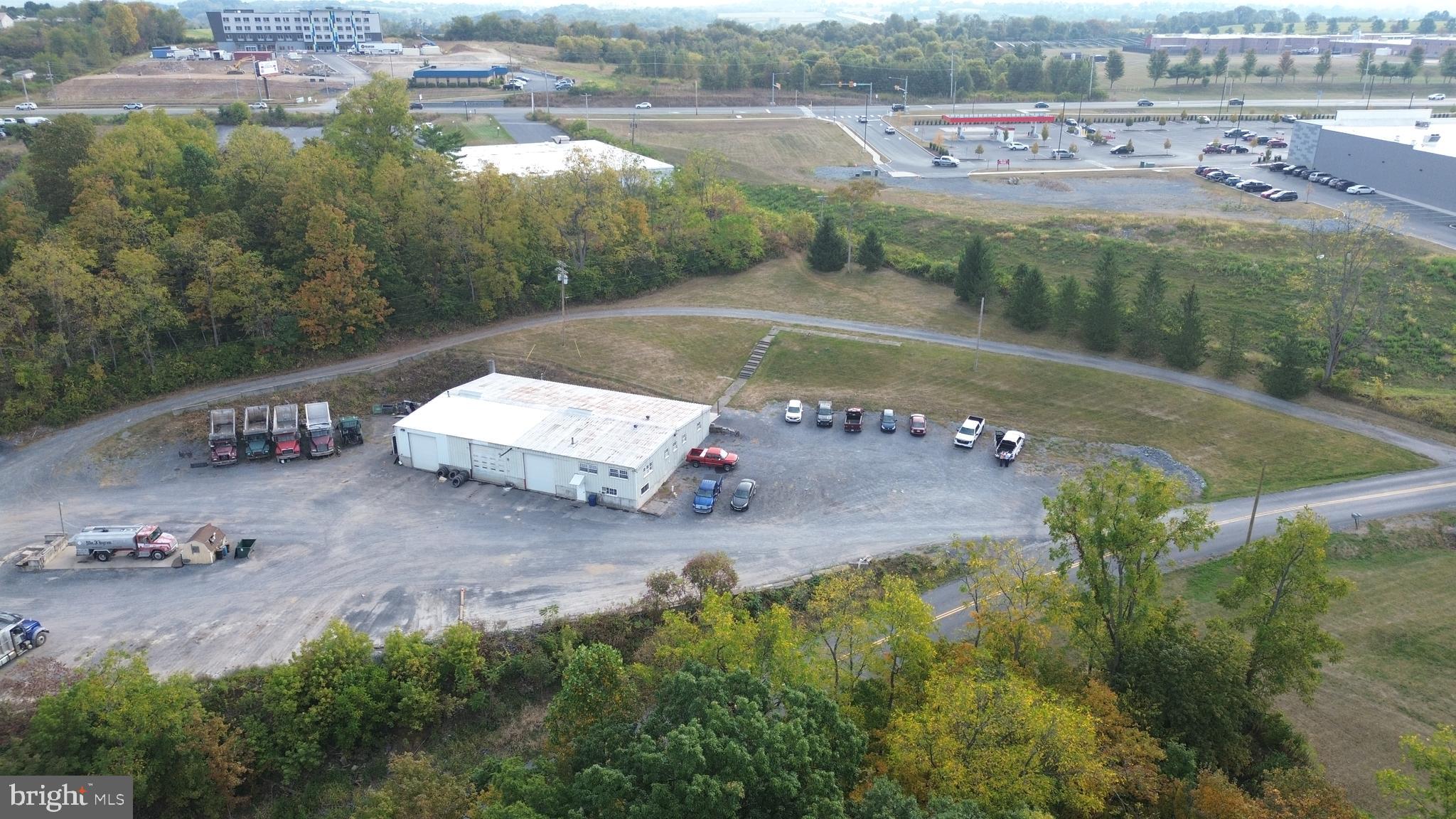 11 acres of prime commercial land located on Paradise Road, Bellefonte adjacent to Interstate 99 and State route 150 (Benner Pike). Parcel offers many uses for this convenient location next to the new Giant grocery store, hotel and Bellefonte Bowling lanes. Great location with 11 acres of land , mostly flat over looking Fisherman's Paradise and I-99 Benner Pike exchange. Property is currently occupied with a trucking company and this operation is not included in the sale, they will be relocating. Ideal opportunity for retail strip mall, mixed use. warehouse or hotel over looking Spring Creek and the beginning of the canyon.
Building #1 Main Garage is 60' x 96' on main level and and additional 1440 square feet of office area on the second floor. The main level of the garage has 4320 sq ft of open garage shop with 1440 sq ft. of area to include Parts room, bathrooms, shower area, break room. The second floor office area has 7 operational rooms. Building #2 is a 28' x 64' block building offering 1792 sq ft. Tax card shows an additional building of 28' x 150' which was removed and will be addressed by the Tax assessor in the next billing cycle.