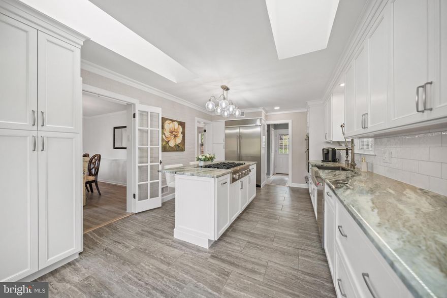 Reimagined from the inside out, this updated all-brick colonial on a private half-acre delivers the finish of new construction with the soul of a home that has been painstakingly cared for. A honed marble foyer and curved wrought iron staircase set the tone: gracious formal rooms, hand-built architectural ceilings, ornamental millwork, and freshly refinished original white oak hardwood floors throughout.

To one side, a formal dining room. To the other, a sunlit step-down parlor beneath a custom ceiling dome and crystal chandelier. Ornamental crown molding, chair rail, and wainscoting carry from room to room. Every interior door is new solid wood, fitted with premium lever hardware. Every exterior door replaced, including a triple-pane steel French patio door with internal blinds.

The family room is anchored by a wood-burning fireplace with carved mantel over a marble-look hearth, painted brick, and an architectural coffered ceiling with dentil molding. French doors open to the renovated gourmet kitchen.

The kitchen, a complete gut renovation, centers on a 48-inch built-in stainless steel refrigerator/freezer, a six-burner professional gas rangetop on the island with telescopic downdraft, and a wall oven and microwave with warming drawer. Floor-to-ceiling custom cabinetry, American-made, solid wood, soft-close, with dual pantries, pull-out drawers, mixer lift, spice storage, and 36-inch double-deep drawers. Quartz countertops, 36-inch farmhouse sink with commercial faucet, 1-HP ultra-quiet disposal, reverse-osmosis filtration, instant hot water dispenser, and subway tile backsplash with adjustable LED lighting. Dual skylights and a bay window with custom built-in seating. Laundry room with custom countertop, mega-capacity front-load washer and dryer, built-in storage, and patio access.

Upstairs, the primary suite opens through double doors to ornamental crown and recessed lighting. The walk-in closet, a converted full bedroom, offers floor-to-ceiling built-in storage with integrated desk. A second walk-in closet. The en-suite spa shower: body jets, rainfall head, hand shower, and tiled bench within a glass enclosure. Cherry vanity with granite top and heated LED mirror.

Two additional bedrooms with hardwood floors and smart ceiling fans with decorative medallions. The hall bath: new porcelain top, faucet, LED mirror, and tile surround with ornamental diamond inlay. The powder room: deep navy walls above white wainscoting, marble-top vanity, and heated LED mirror.

The finished walkout lower level offers flexible living with premium luxury vinyl flooring, a dedicated room with closet, and a full bathroom built from scratch. Walk-in shower in marble-look porcelain floor to ceiling, dual niches with mosaic accent, frameless glass enclosure, fold-down bench, heated fan, and marble-top vanity. Cedar-lined closet and open recreation area.

Systems match the surfaces. A 2024 high-efficiency dual-fuel HVAC, heat pump with variable-speed blower paired with a 97% gas furnace, 10-year manufacturer warranty, whole-house humidification, air purification, and near-HEPA filtration. 200-amp electrical. Large 55-gallon water heater and stainless steel chimney liner. 

Smart thermostat, smart lighting, interconnected smoke detectors. Overhead lighting in every room: recessed fixtures, chandeliers, dimmers, and coordinated exterior package. Cellulose attic insulation with radiant barrier.

Outside, brand new driveway built from a premium base, extending to the rear patio, with one-year warranty, expansive, multi-level deck with built-in seating, curtained gazebo, and a fully fenced backyard. Brick paver patio, cedar playground, organic garden beds, stone retaining walls, arborvitae screening, and mature plantings on an organic lawn. Heated attached garage with premium insulated door.

Pet-free and scent-free. Truly turnkey and move-in ready.