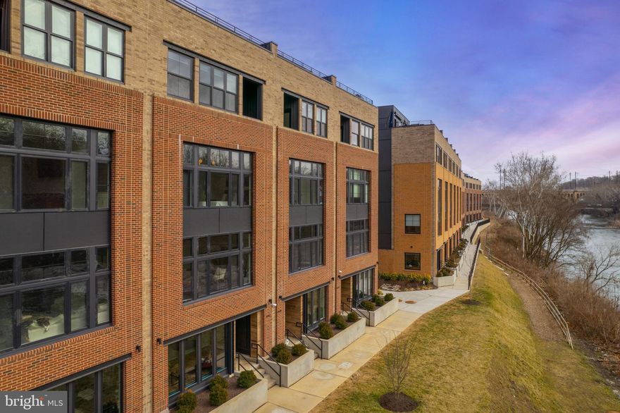 Stroll to dinner on Main Street, walk the historic Manayunk Canal Path, take the nearby train into the city, or catch a gorgeous sunset from your roof deck at this impeccable newly constructed townhome in the riverside community of Locks in Manayunk. Decked out with every high-end luxury upgrade you could wish for, this 4 bedroom, 3.5 bath house comes complete with a Savant home automation system, Lutron controlled lighting and shades, 4K ultra-HD projector for cozy, at-home movie nights, 5-stop elevator and a sound system. The ground floor offers a sunlit study with custom built-ins and beautiful views of the Schuylkill River, and an oversized 2-car garage. As soon as you enter the main floor you are immediately struck by the exquisite finishes, the floor to ceiling windows allowing for incredible natural light and a functional, open floor plan, perfect for everyday living or entertaining family and friends. The gourmet kitchen will delight the home chef, with custom shaker cabinets, Wolf 6-burner range, Sub-Zero refrigerator, large center island with quartzite counters, pantry, spacious dining area and breakfast area with custom built-ins and beverage refrigerator. The living area features beautiful views of the river, with an ultra-HD theater-quality projector and screen, and high-end Lutron UV blocking shades that lower at the touch of a button. The third floor features a large bedroom overlooking the water, with dual closets and full bath with walk-in shower. An additional two bedrooms, one being used as an office, a full hall bath and convenient laundry room complete this level. The fourth floor serves as the luxe owner’s retreat, with primary bedroom with Lutron blackout shades, large walk-in closet, additional 2 closets, and a private balcony with river views that will become your ultimate morning coffee spot. The expansive primary bath features dual vanities, walk-in marble shower and large soaking tub. Relax in the adjacent sitting room, or make morning coffee at the convenient beverage center. Topping off this fabulous home is the roof deck, with Ipe wood decking, built-in lighting and sound system, showcasing expansive, sunset views of the Schuylkill River and Manayunk.  All this and 7 years remaining on the Tax Abatement! Set in an ultra-convenient location, just blocks from Main Street, the Schuylkill River Trail, the Manayunk train station and 76.