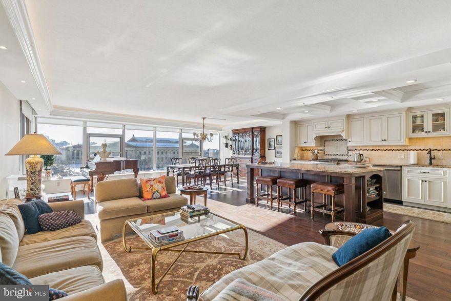 Impeccably designed two bedroom with spectacular views of the Philadelphian Museum of Art and private terrace at The Philadelphian. This completely renovated home features two bedrooms, two bathrooms, excellent entertaining space, generously sized rooms, a gorgeous chef's kitchen, 225 square foot private terrace, and oversized west-facing windows in all rooms, directly overlooking the Art Museum and Center City. Enter through the welcoming foyer with two coat closets into the grand, open great room boasting a wall of windows that shower the room in natural light, architectural ceiling details with accent lighting, rich hardwood floors, a custom kitchen, and ample space for living, formal dining, and entertaining. Off of the dining area is a large sliding door leading to the private terrace, perfect for dining al fresco and watching the sun set over the Art Museum. The beautiful chef's kitchen offers custom wood cabinetry with built-ins and under-cabinet lighting, granite countertops, designer tile backsplash, large stainless steel sink with garbage disposal, a massive center island with excellent storage space and breakfast bar, stunning coffered ceiling, and a full suite of stainless steel appliances including an oven with five-burner gas range and a French door refrigerator with water dispenser and freezer drawer. The spacious primary suite features a wall of windows, space for an additional seating area, a large walk-in closet with beautiful built-ins, and an ensuite bathroom appointed in designer tilework with large white vanity, additional built-in vanity, built-in linen storage, floating toilet, and glass-enclosed corner shower with stone bench. The second bedroom is generously sized and has another wall of windows, built-in wood entertainment center with display shelves and storage, and a deep wall closet. It enjoys use of a marble-appointed hall bathroom with modern vanity, linen closet, glass enclosed walk-in shower, and designer tilework throughout. Additional home highlights include recessed lighting and custom light fixtures, beautiful millwork and trim, and a laundry room off of the foyer with side-by-side washer and dryer, excellent storage space, and tile floor. The Philadelphian has often been called a “city within a city” due to the many services and amenities that its residents enjoy. These include a restaurant, grocery store, multiple medical offices, and a beauty parlor. Residents of The Philadelphian rarely have to travel far to accomplish their daily routine, but when the need to leave arises, the building offers a shuttle bus that runs all day long dropping off and picking up residents throughout Center City. Residents also enjoy a 24-hour doorman, indoor and outdoor pools, and a fitness center. On-site garage parking is available for rent (subject to availability).