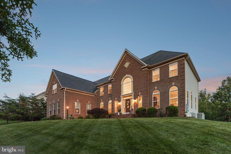 The one you've been waiting for! Located in the desirable & quaint Occoquan Park neighborhood, this classic brick-front colonial was built in 2012, the home sits on over an acre of well-maintained land, offering a substantial front and backyard, bordered by mature trees for added privacy and natural appeal. Upon entry, the two-story foyer immediately opens up with dual staircases, creating a functional and visual focal point. Hardwood flooring and large windows set the tone for a bright, open layout throughout the main level. The kitchen is designed with both everyday usability and entertaining in mind! A massive center island serves as the anchor of the space, surrounded by stainless steel appliances, granite countertops, and abundant cabinetry. A generous walk-in pantry provides extra storage, while the open flow connects to the informal dining area and main living space, enhancing the home's usability. Upstairs, there are four sizable bedrooms, including a spacious primary suite with vaulted ceilings & 2 large walk-in closets. Each bedroom features ample closet space, and the upper-level layout promotes privacy while still being conveniently connected. The fully finished basement adds significant livable space, perfect for recreation, home gym, guest suite, or media area. Set on more than an acre, the lot provides a rare sense of space in a Northern Virginia suburban setting. The back of the property opens to a wooded area, adding privacy and a natural buffer. There's plenty of room for outdoor activities, gardening, or potential expansions like a patio or deck. This home is situated in the Occoquan Park area of Lorton, a quiet residential pocket known for its proximity to the Occoquan River, Occoquan Regional Park, and the historic town of Occoquan. The neighborhood offers a blend of nature and convenience—trails, kayaking, and park space are just minutes away, while I-95, the VRE (Virginia Railway Express), and major commuting routes provide easy access to Washington, D.C. and Fort Belvoir.