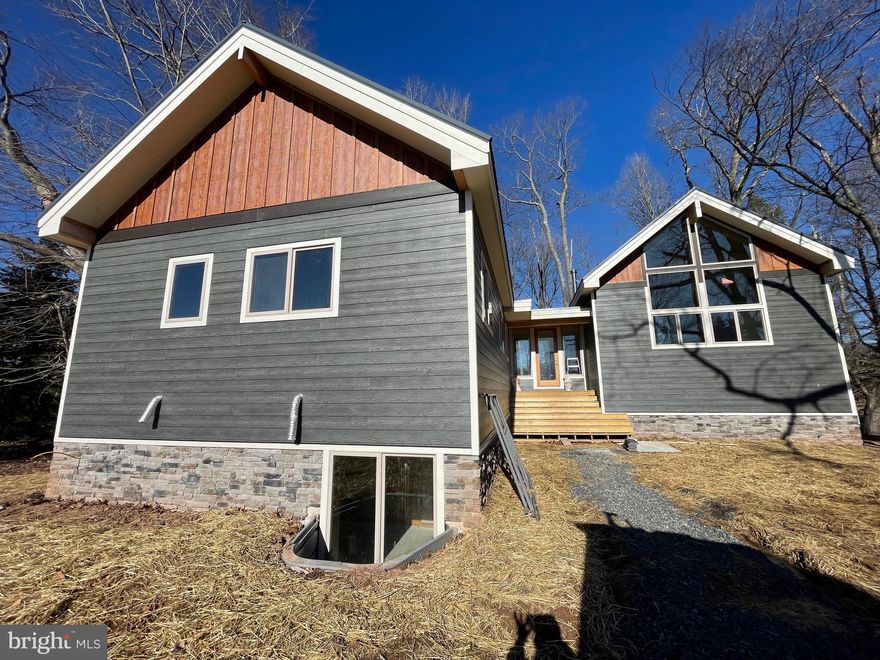 Contemporary Lake Front Home in Waterfront Greens – New Construction 7 Bedroom 6 Bathroom Home with outdoor deck overlooking Deep Creek Lake. Vaulted ceilings, open floor plan, sleek modern asthenic throughout.  Second living space in the walkout basement, adjoining your personal indoor pool. Centrally located to local establishments, state parks, Wisp Resort and more.